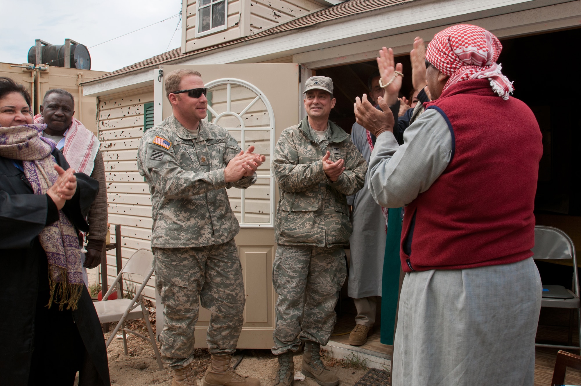 Role-playing actors give Col. Warren Hurst (center), commander of the Kentucky Air National Guard's 123rd Contingency Response Group, and Army Maj. Keith Pruett, commander of the 690th Rapid Port Opening Element from Fort Eustis, Va., an Arabic welcome to the fictional village of Sabor, Nessor, on March 28, 2012. Both were participating in Eagle Flag, an exercise designed to simulate a deployed environment at Joint Base McGuire-Dix-Lakehurst, N.J. (U.S. Air Force photo by Maj. Dale Greer)
