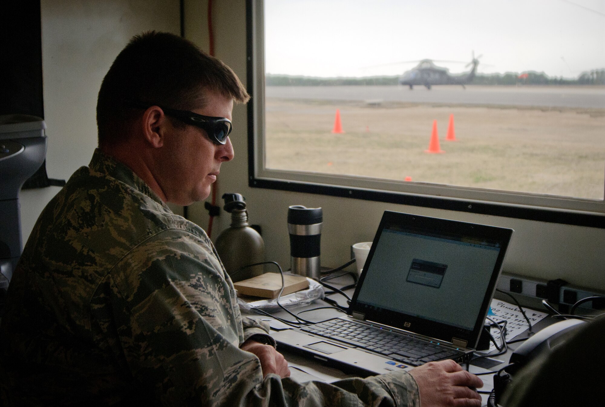 Maj. Ash Groves, air operations officer for the Kentucky Air National Guard's 123rd Contingency Response Group, monitors air traffic March 28, 2012, at Lakehurst Naval Air Engineering Station, N.J., while sitting in a Hard-sided Expandable Lightweight Air-Mobile Shelter. The HELAMS served as a Joint Operations Center for Army and Air Force personnel running a Joint Task Force-Port Opening as part of Eagle Flag, an exercise designed to test the ability of U.S. forces to operate in a deployed environment. (U.S. Air Force photo by Master Sgt. Phil Speck)