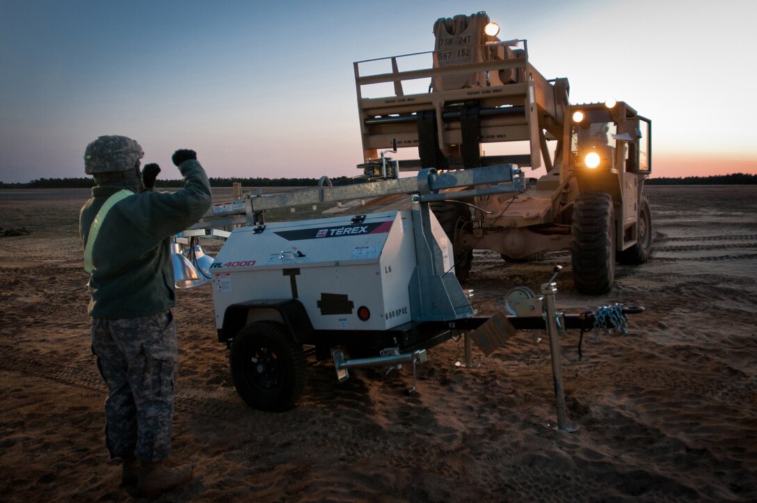 Soldiers from the U.S. Army's 690th Rapid Port Opening Element, based in Fort Eustis, Va., position a lighting cart near the flight line at Joint Base McGuire-Dix-Lakehurst, N.J., during Exercise Eagle Flag March 26, 2012. The element is working with the Kentucky Air National Guard's 123rd Contingency Response Group to establish an aerial port at Lakehurst Naval Air Engineering Station within 24 hours of arrival. (U.S. Air Force photo by Maj. Dale Greer)