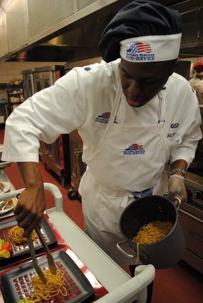 Lt. Col. Demetrius Walters, 10th Missile Squadron commander, plates a helping of pasta for his team's Thai Chicken Sauté for the Warrior Chef Competition. (U.S. Air Force photo/Senior Airman Kristina Overton) 

