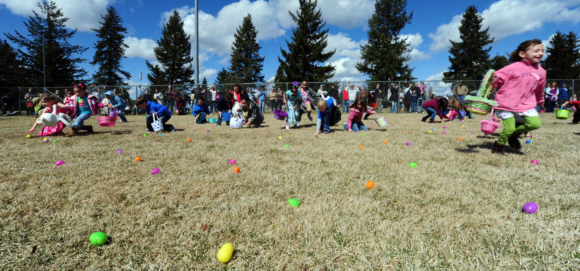 Children, ages 5 to 7, rush forward to retrieve Easter eggs scattered around the baseball field in Miller Park at Fairchild Air Force Base, Wash., April 7, 2012. The Easter egg hunt event was sponsored by Balfour Beatty. There was also a separate egg hunt designed especially for children ages 1 to 4. Prizes were raffled out to children that received eggs with a special ticket located inside. (U.S. Air Force photo by Airman 1st Class Taylor Curry/Released)