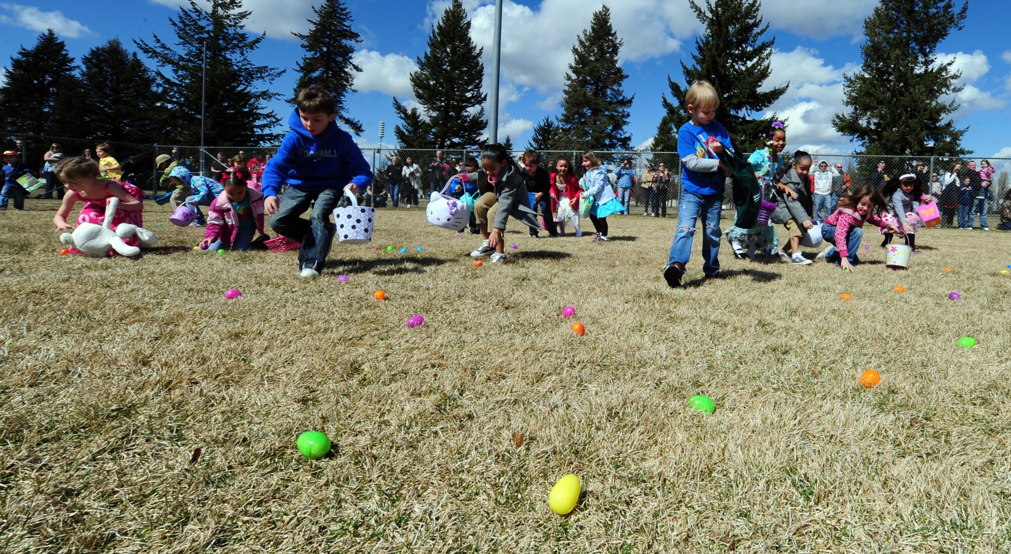 Children, ages 5 to 7, rush forward to retrieve Easter eggs scattered around the baseball field in Miller Park at Fairchild Air Force Base, Wash., April 7, 2012. The Easter egg hunt event was sponsored by Balfour Beatty. There was also a separate egg hunt designed especially for children ages 1 to 4. Prizes were raffled out to children that received eggs with a special ticket located inside. (U.S. Air Force photo by Airman 1st Class Taylor Curry/Released)