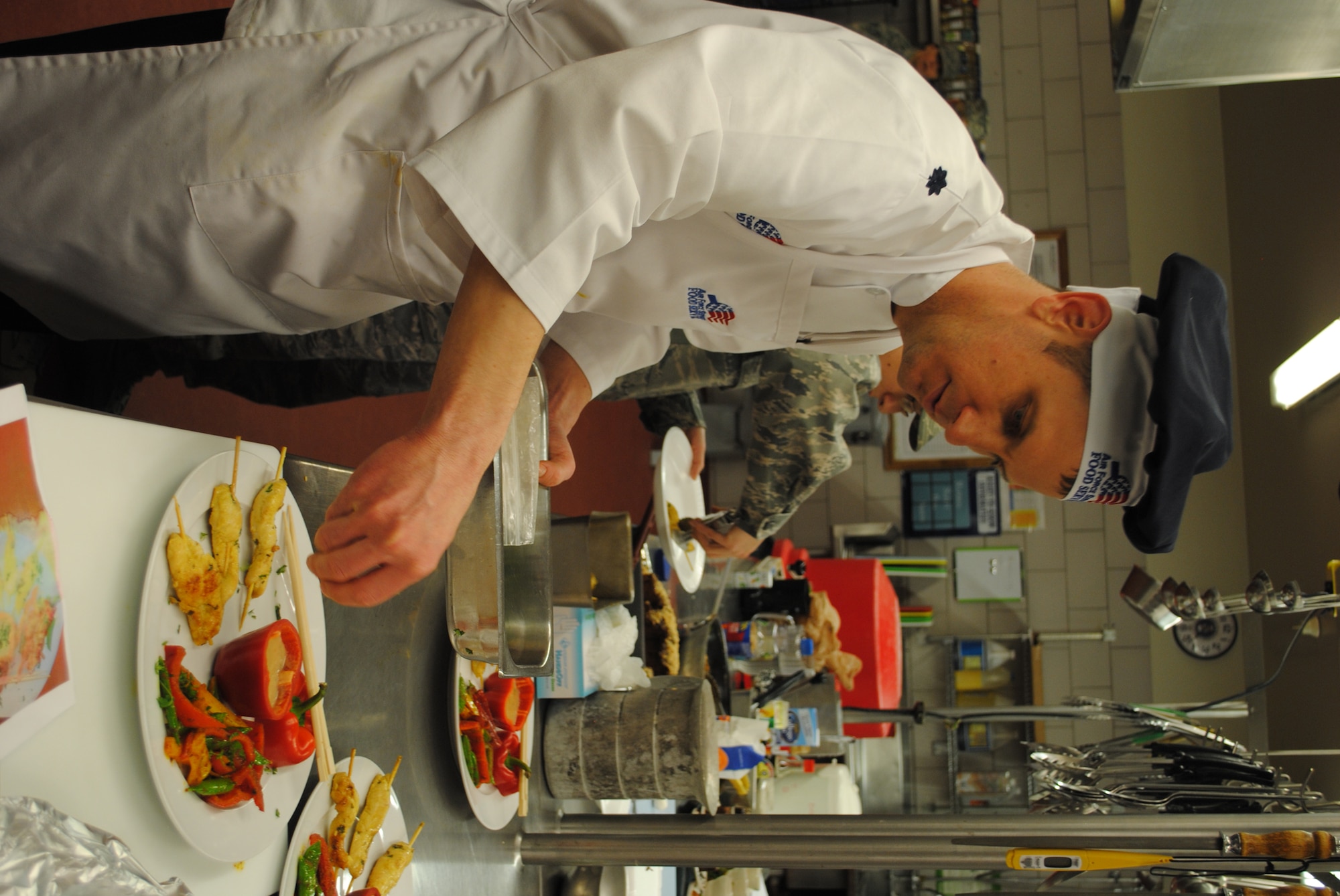 Lt. Col. Matthew Guenther, 490th Missile Squadron commander, sprinkles cilantro on his Chicken Sate Skewers. (U.S. Air Force photo/Senior Airman Kristina Overton)