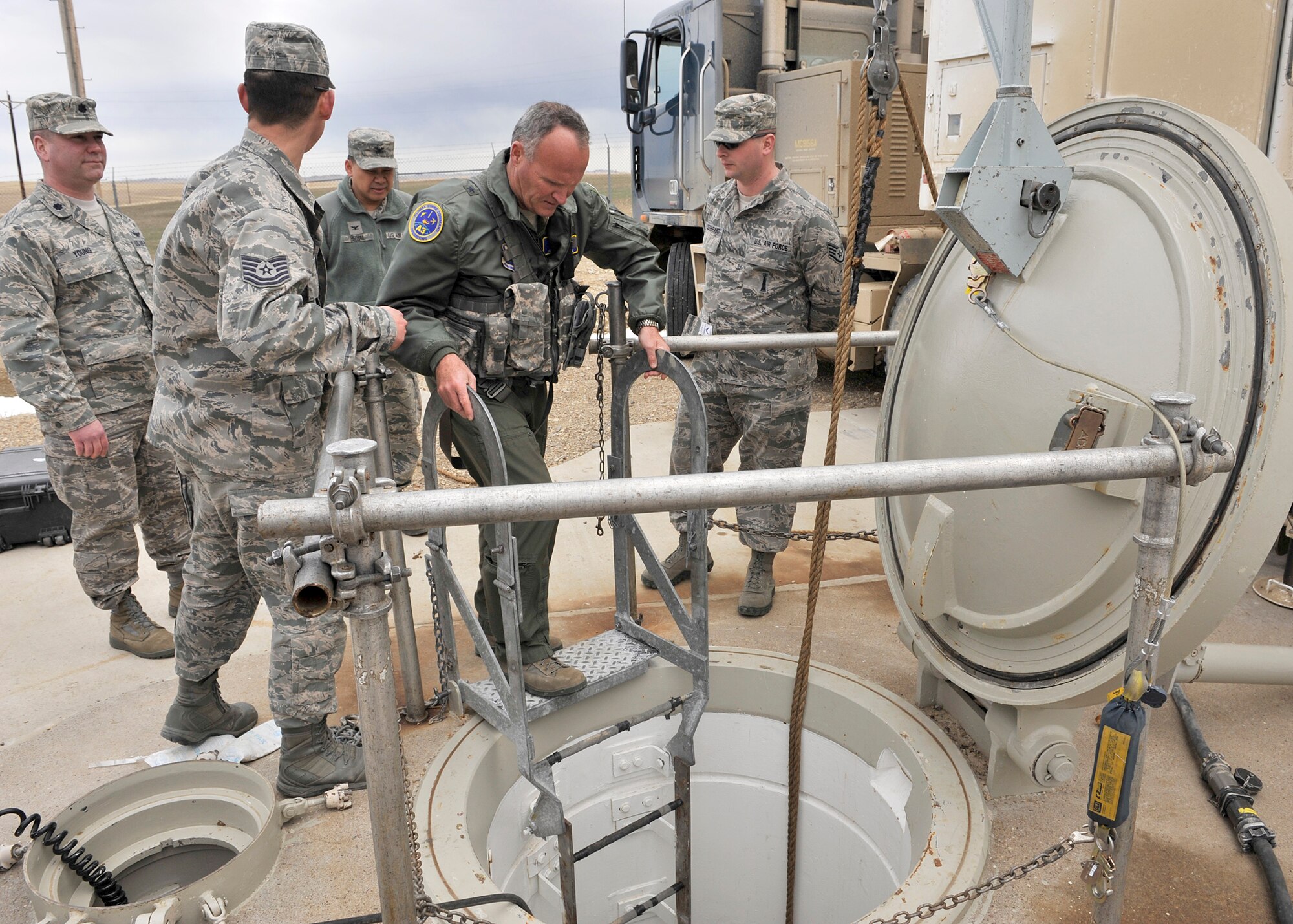 Brig. Gen. James Browne Air Force Global Strike Command's Air, Space and Information Operations chief, prepares to descend into a launch facility maintenance tube to observe a team perform maintenance on a missile. Also pictured, left to right, are Tech. Sgt. Jordan Mohr, Lt. Col. Brian Young, Col. H.B. Brual, and Staff Sgt. James Hildebrand. (U.S. Air Force photo/John Turner)