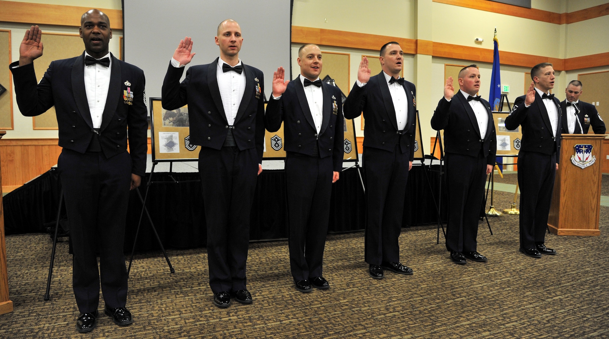 Team Malmstrom recognized the newest members of the Big Sky First Sergeants group during a recognition ceremony at the Grizzly Bend March 28. Being sworn in from left to right are Master Sergeants Shannon Wells, Bradley Thye, William Baccus, David Carr, Colin Crandall and Jeremiah Martin. At the podium (far right) is Master Sgt. Shane Matt, 341st Maintenance Operations Squadron first sergeant. The new inductees are assigned as first sergeants in the following squadrons: Wells, 341st Security Forces Squadron; Thye, 341st Logistics Readiness Squadron; Baccus, Civil Engineer Squadron; Carr, 341st Force Support Squadron; Crandall, 341st Medical Group; and Martin, 341st Operations Group. (U.S. Air Force photo/John Turner)
