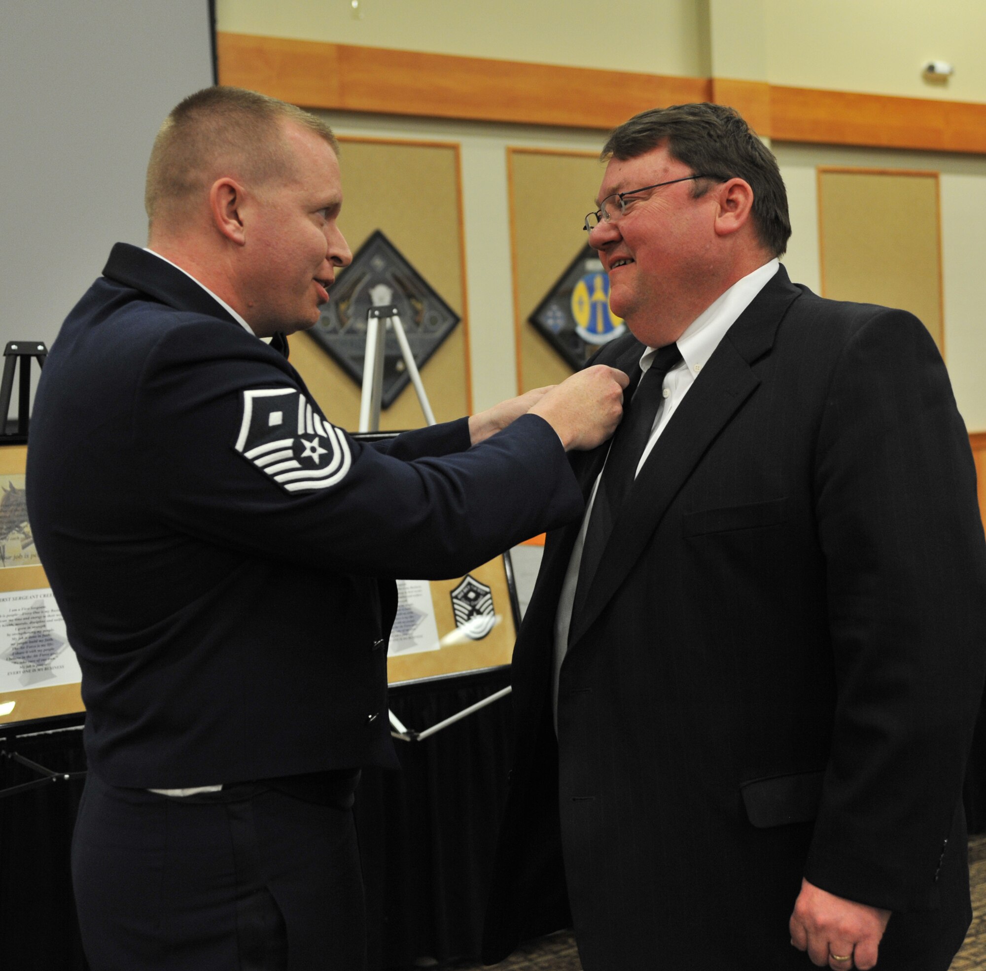 Master Sgt. Herbert Carrol, first sergeant for the 741st Missile Security Forces Squadron, recognizes Steve Grooms, 1st Liberty Federal Credit Union chief executive officer, as an honorary Malmstrom first sergeant during the induction ceremony March 28. (U.S. Air Force photo/John Turner)
