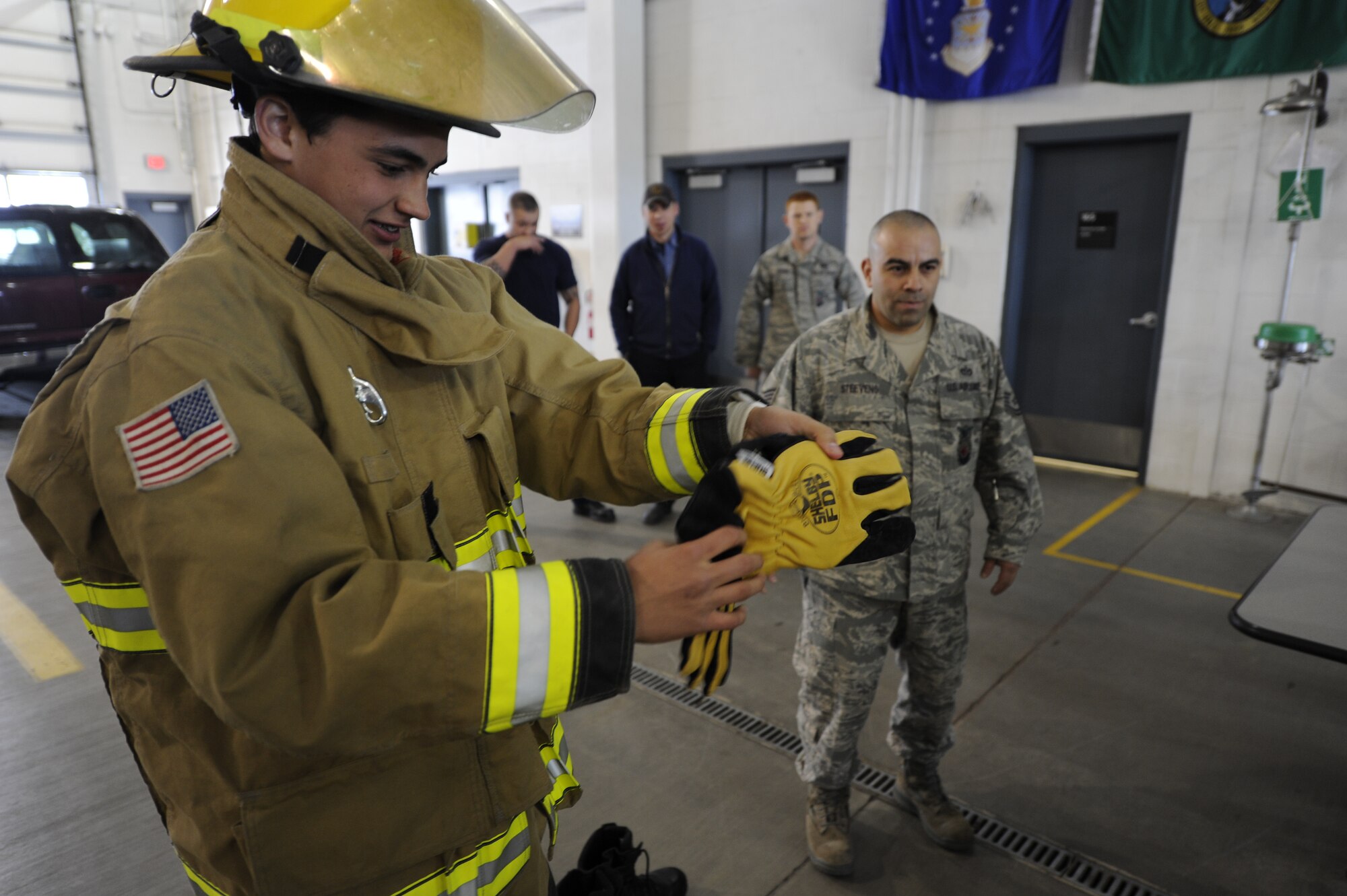 An Oroville, Wash., Border Patrol Explorer student attempts to put on fire protection gear in less than one minute in the firehouse at Fairchild Air Force Base, Wash., April 4, 2012. Fairchild’s firemen are able to get ready in less than one minute, in order to minimize response time. (U.S. Air Force photo by Airman 1st Class Ryan Zeski/Released)