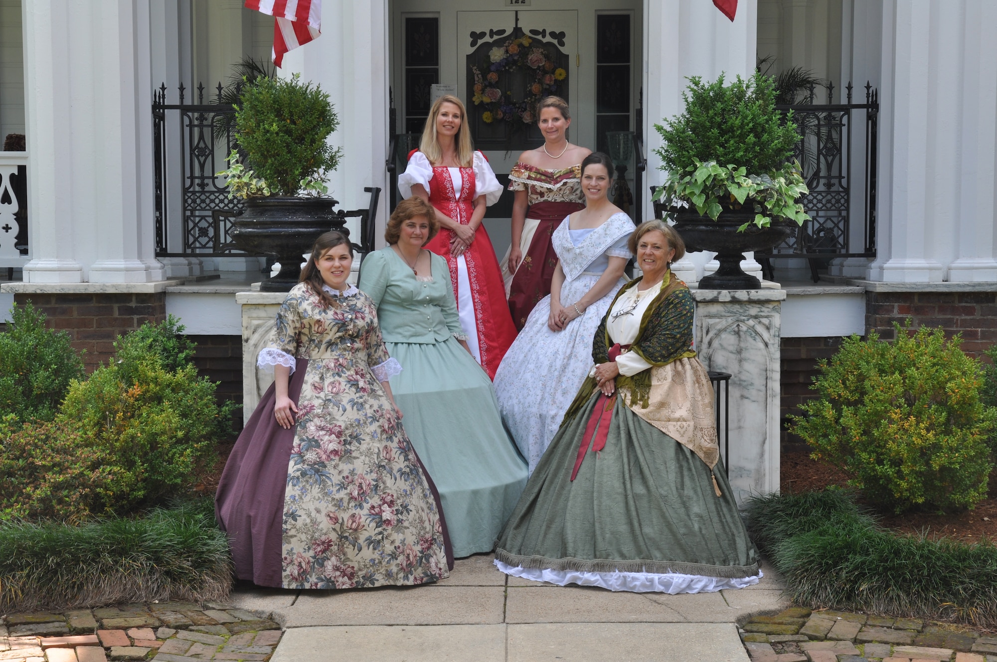 Air Force spouses stand on the steps of the White Arches home in Columbus, Miss. on April 2 after being volunteer hostesses for the annual Spring Pilgrimage.  Columbus hosts the event every year as a way of helping others experience some of the history the town has to offer.  (U.S. Air Force Photo/Airman 1st Class Charles Dickens)