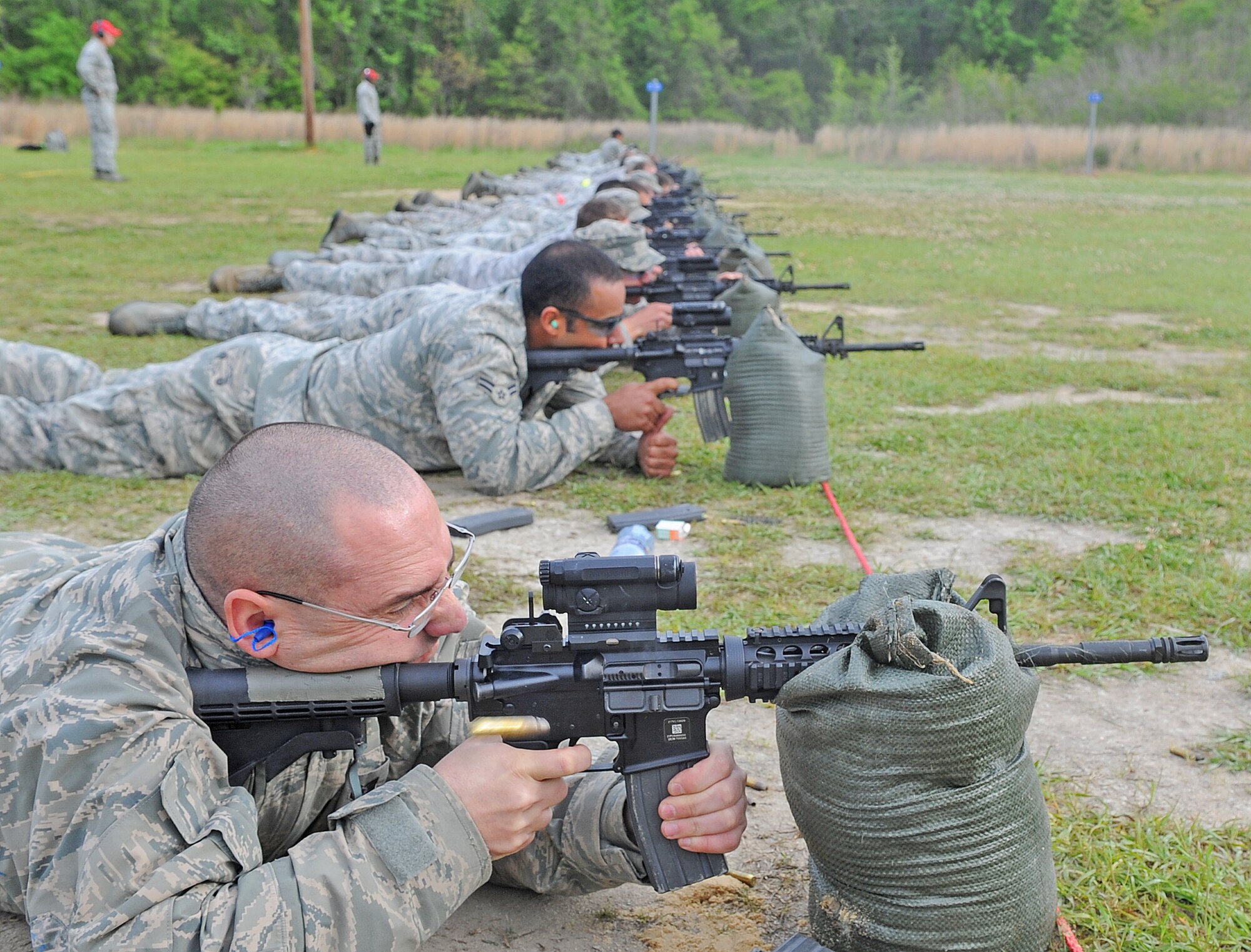 Airmen fire their M4 carbines during a combat arms training and maintenance course at Howell Woods Firing Range in Smithfield, N.C., April 9, 2012. During the course Airmen learn how to effectively fire, disassemble, and clean their weapons. The skills they learn in the course will help them to perform those tasks on their weapons while in a deployed location. (U.S. Air Force photo/Senior Airman Gino Reyes/Released)