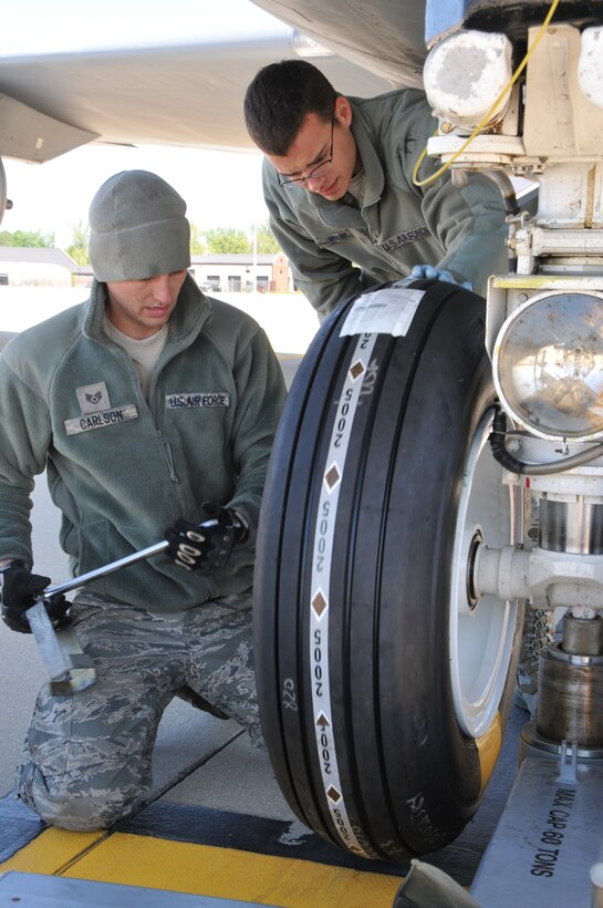 Staff Sgt. Cody Carlson (left) and Airman 1st Class Colby Mercil, Crew Chiefs assigned to U.S. Air Force aircraft 80104, a KC-135R Stratotanker, prepare to tighten a lug nut with a torque wrench while installing a new nose gear tire on April 10, 2012. Staff Sgt. Carlson, from Sandwich, Ill., is a Guardsman assgned to the 126th Maintenance Squadron while Airman Mercil, from Colorado Springs, Col., is assigned to the 906th Air Refueling Squadron, an active duty Air Force unit that is associated with the 126th Air Refueling Wing, Illinois National Guard, at Scot AFB, Ill. Crew chiefs perform and oversee everyday maintenance to aircraft. They recover and inspect aircraft after a flight, change tires and brakes, service engine oil and hydraulic fluid, and execute numerous inspections. They ensure an aircraft is safe and reliable. (National Guard photo by Master Sgt. Ken Stephens)