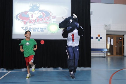 David Alderich, Joint Base San Antonio-Randolph Youth Center patron, does the "Running Man" dance with El Toro, Mascot of the Houston Texans football team, at the JBSA-Randolph Youth Center April 4. El Toro was at the youth center to promte nutrition and exercise. (U.S. Air Force photo by Rich McFadden) 