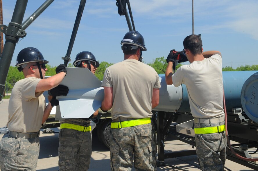 Airmen from the 7th Munitions Squadron drill fins onto inert bombs, April 11, 2012, at Dyess Air Force Base, Texas. The fins are designed to help guide the bomb as it is released from the aircraft. The bomb represents a Mark-84 which weighs approximately 2,000 pounds. (U.S. Air Force photo by Airman 1st Class Cierra Bullock/Released)