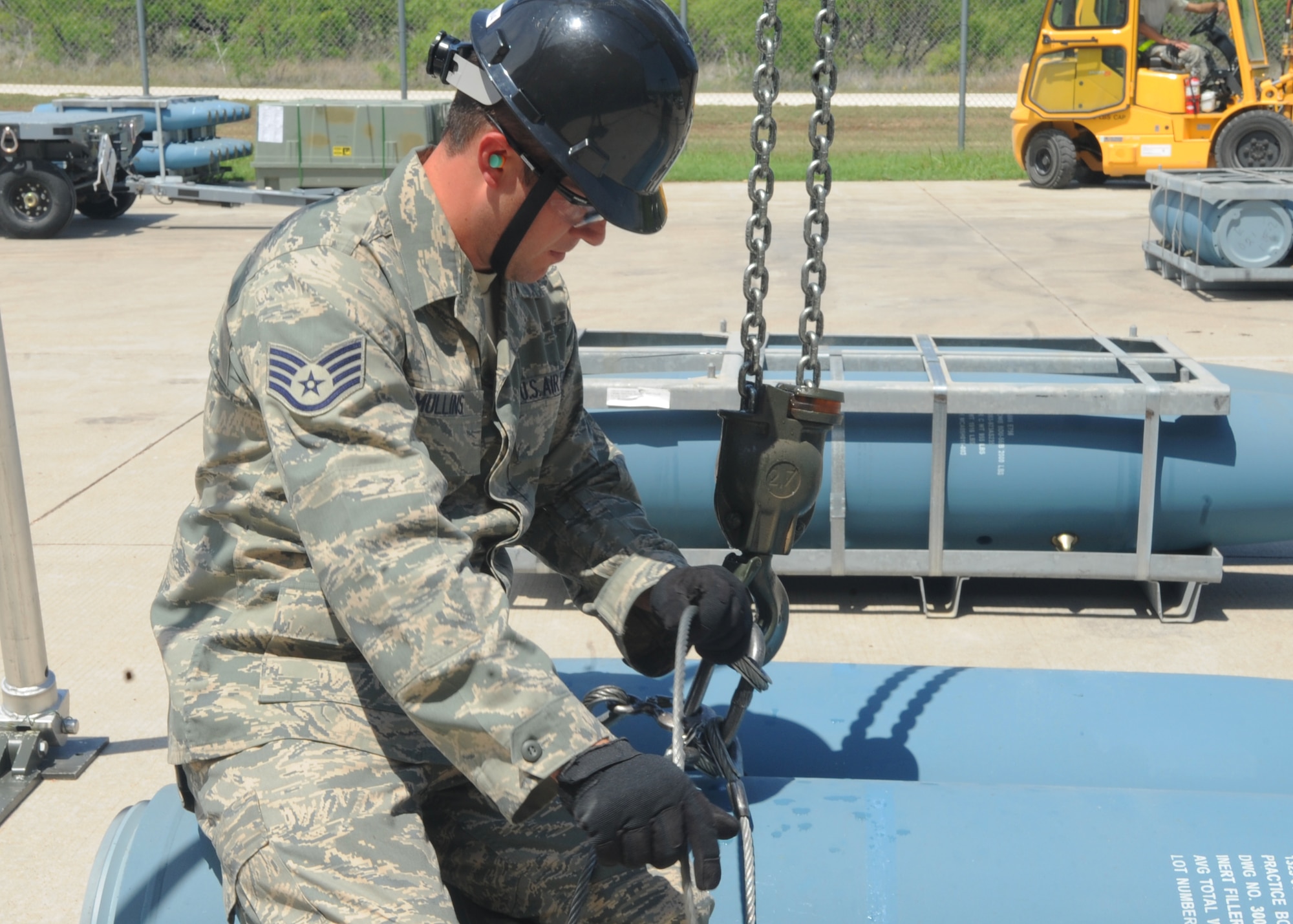 Staff Sgt. Brett Mullins, 7th Munitions Squadron, latches an inert bomb onto a hoist as part of training April 11, 2012, at Dyess Air Force Base, Texas. The bomb represents the Mark-84 which is a penetrating bomb that weighs approximately 2000 pounds. (U.S. Air Force photo by Airman 1st Class Cierra Bullock/ Released)
