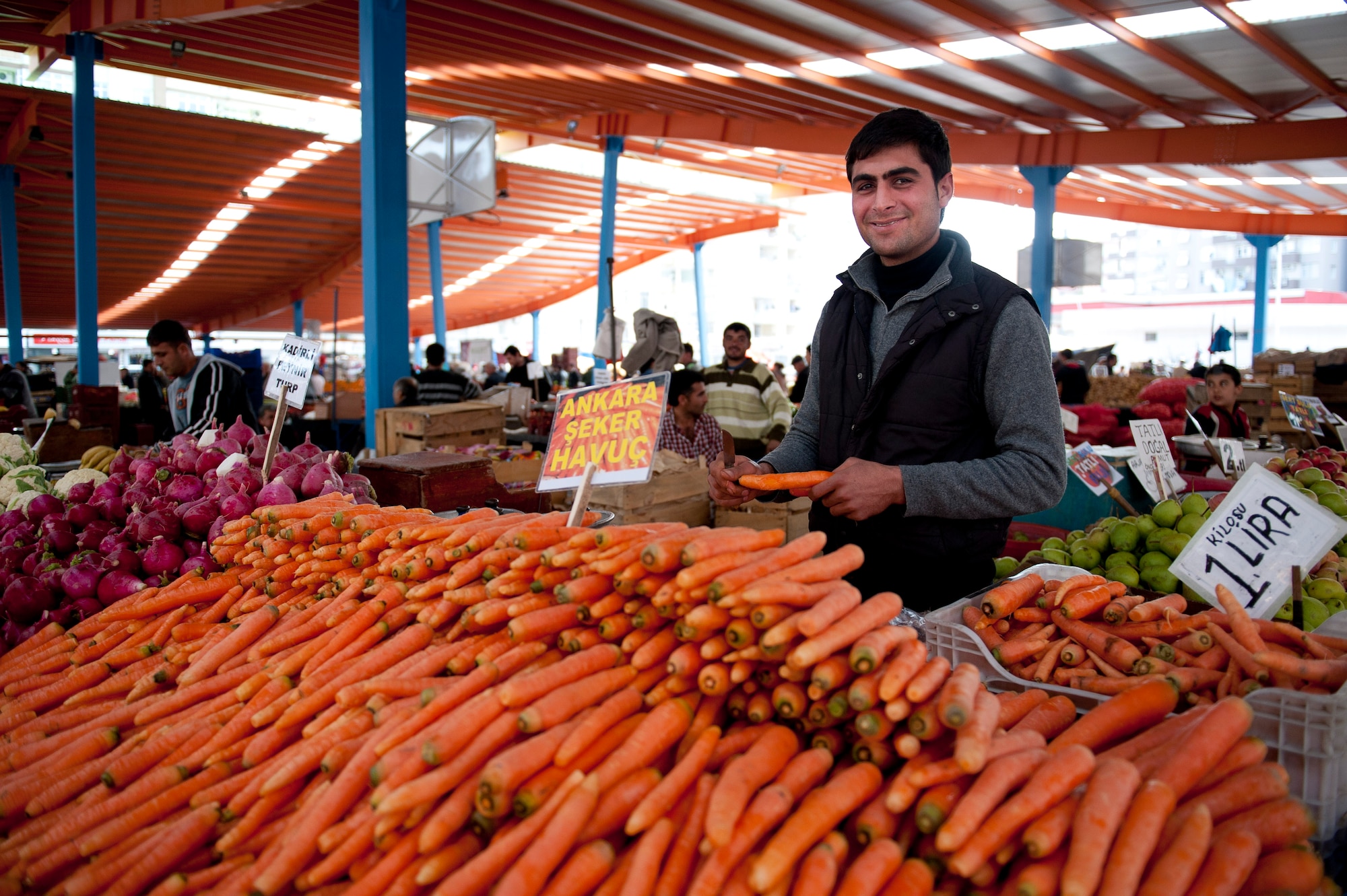 A vendor peels carrots for shoppers to sample at a farmers market March 8, 2012, in Adana, Turkey. The fertile soil around Adana allows farmers to grow many types of produce, keeping prices low and fruits and vegetables fresh. (U.S. Air Force photo by Tech. Sgt. Michael B. Keller/Released)