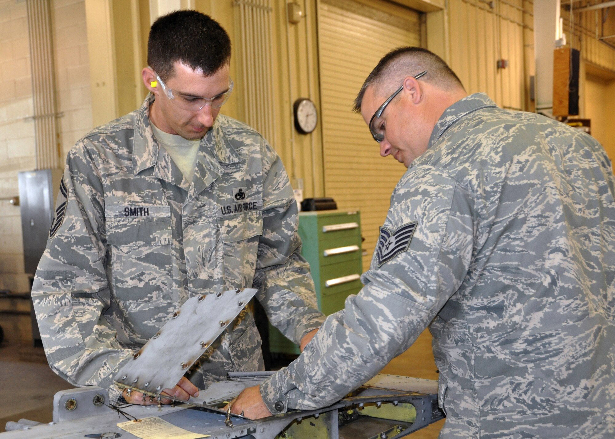 Senior Master Sgt. John Smith, fabrication flight chief with the 307th Maintenance Squadron, helps Tech. Sgt. Heath Knefely, a 307th MXS structural repair technician, open a panel on an A-10 pileon for inspection at Barksdale Air Force Base, La., March 3, 2012.  Sergeant Smith was recently named the 307th Bomb Wing Senior Noncommissioned Officer of the Year for 2011.  (U.S. Air Force photo by Master Sgt. Mary Hinson/Released)
