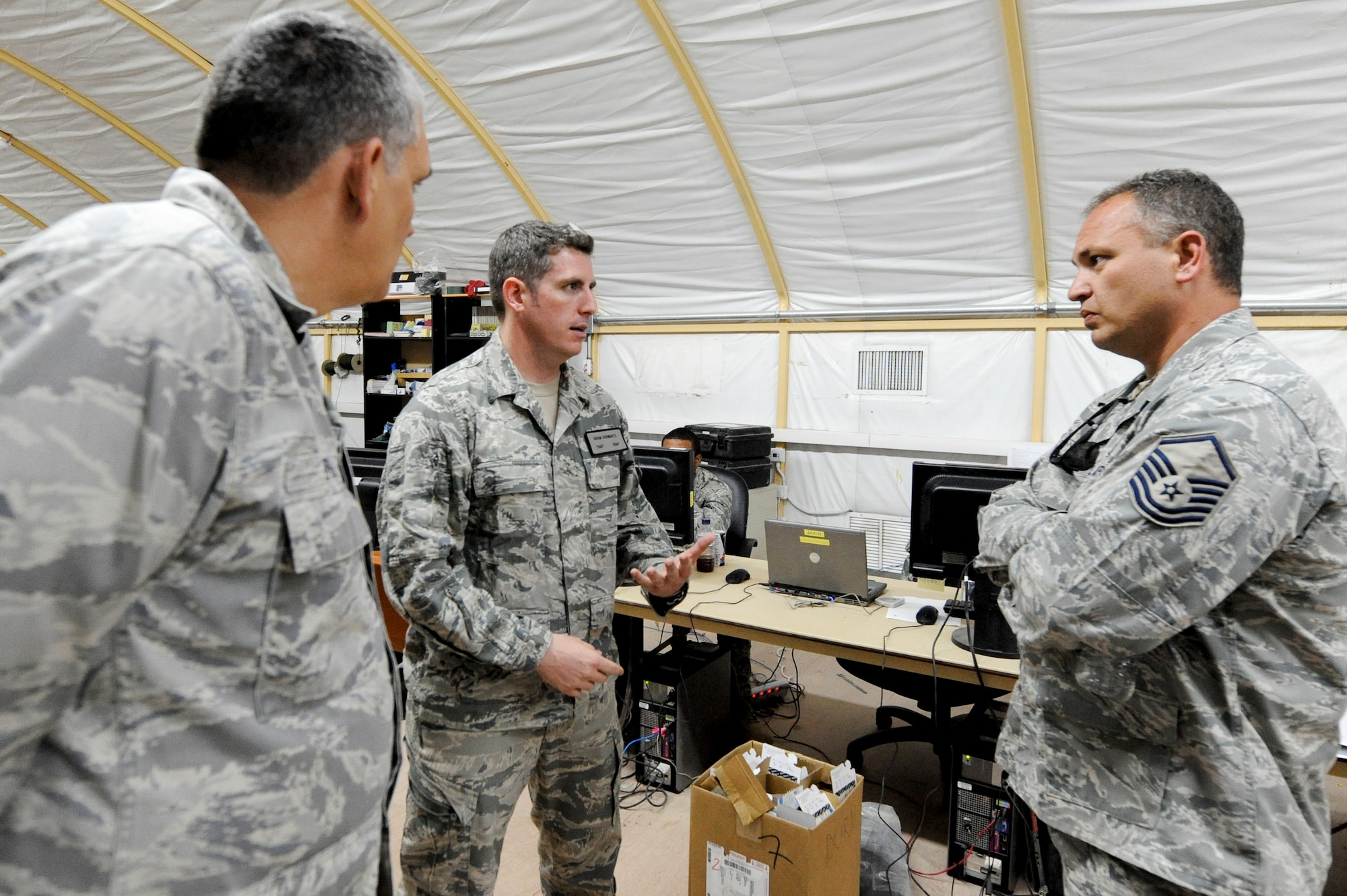 CAMP BUEHRING, KUWAIT -- Tech. Sgt. Adam Schwartz, 82nd Expeditionary Air Support Operations Squadron joint terminal air controller, center, shares past experiences with Lt. Col. Robert O'dell, 332nd Air Expeditionary Wing chaplain, and Master Sgt. Ralph Tomeo, 332nd AEW anti-terrorist NCO, during their visit to the 82nd EASOS squadron here, April 10, 2012. Schwartz explained how the unit provided close air support for ground troops during Operation New Dawn. Schwartz is deployed from Ft. Hood, Texas. O'dell is deployed from Barksdale, La., and is a native of Brownstown, Ill. Tomeo is deployed from Joint Base McGuire-Dix-Lakehurst, N.J. and is a native of New York. (U.S. Air Force photo by Staff Sgt. Joshua J. Garcia)