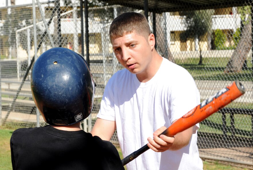Samuel McKenzie, 39th Communications Squadron, demonstrates proper batting techniques to a player during baseball spring training camp April 10, 2012, at Incirlik Air Base, Turkey. Players ages 9-18 took part in the training to prepare for the Youth Center Baseball Tournament, which kicks off April 21. (U.S. Air Force photo by Senior Airman Jarvie Z. Wallace/Released)