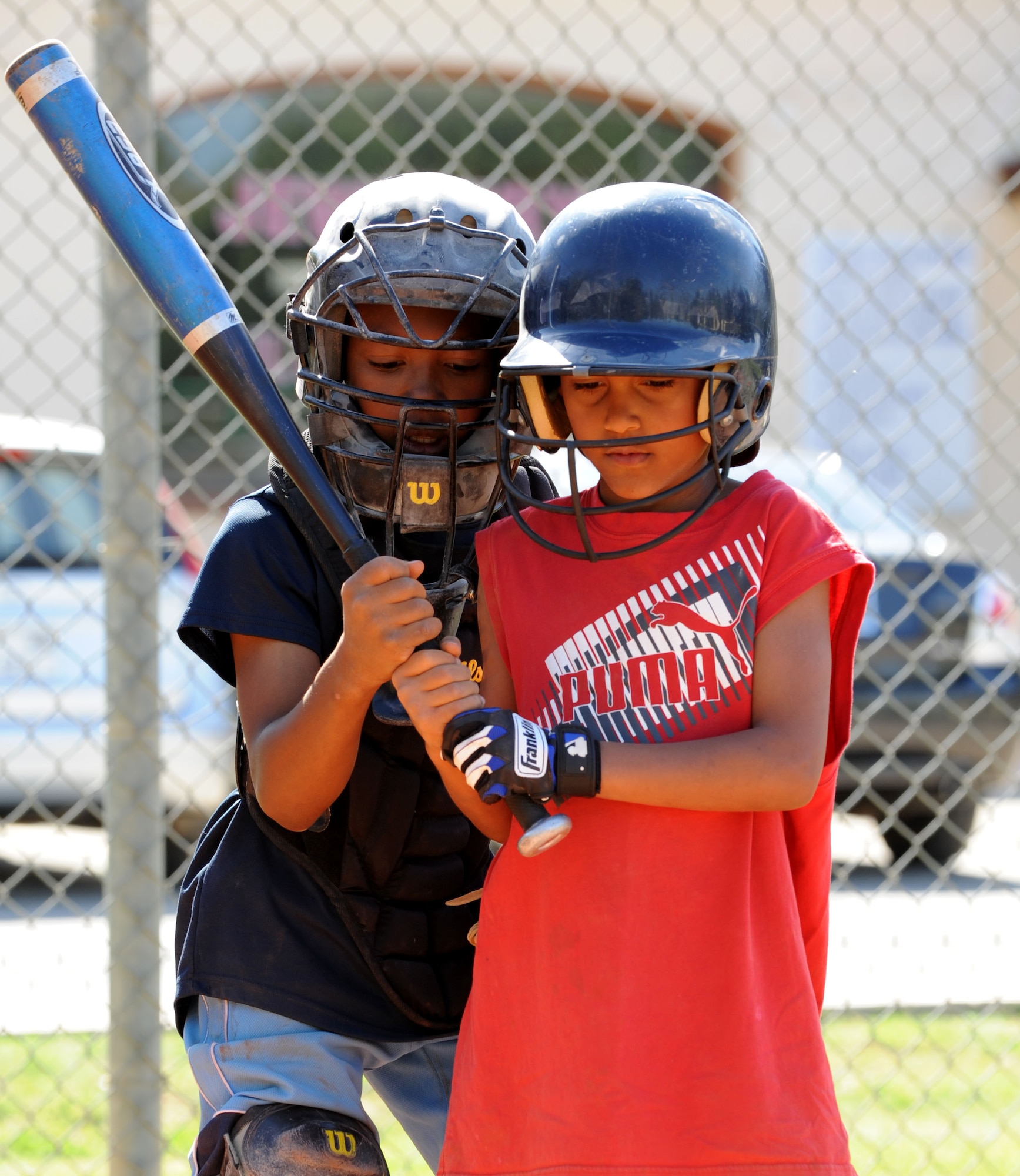 A player shows his peer how to properly hold a bat during baseball spring training camp April 10, 2012, at Incirlik Air Base, Turkey. Players ages 9-18 took part in the training to prepare for the Youth Center Baseball Tournament, which kicks off April 21. (U.S. Air Force photo by Senior Airman Jarvie Z. Wallace/Released)
