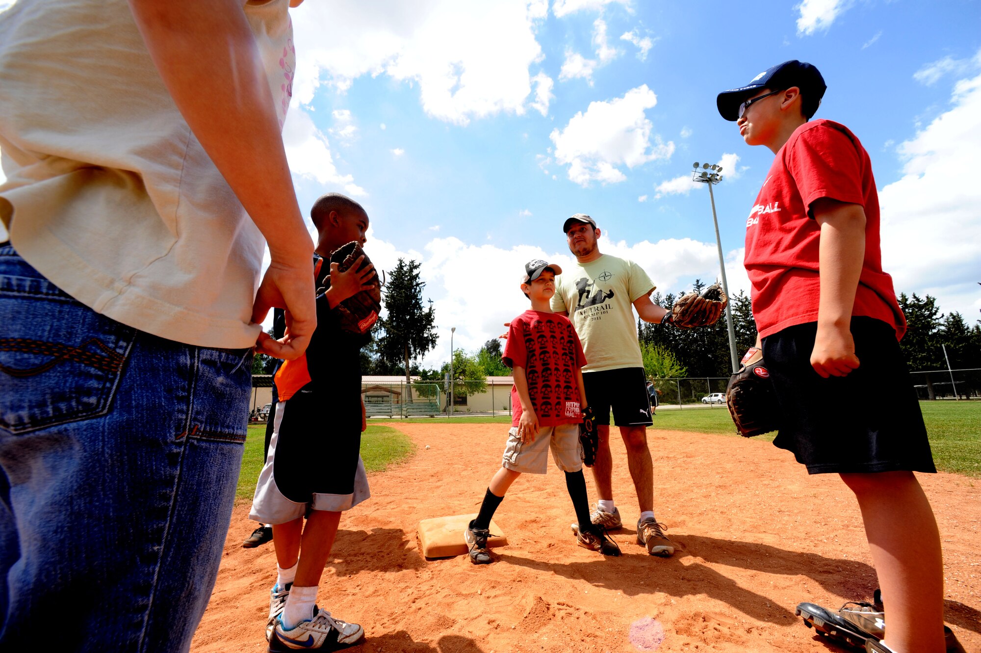 Roy Perez, Incirlik Youth Center youth program assistant, center, speaks to players during baseball spring training camp April 10, 2012, at Incirlik Air Base, Turkey. Players ages 9-18 took part in the training to prepare for the Youth Center Baseball Tournament, which kicks off April 21. (U.S. Air Force photo by Senior Airman Jarvie Z. Wallace/Released)
