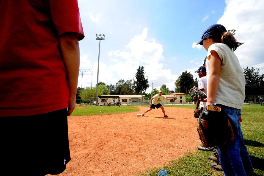 Roy Perez, Incirlik Youth Center youth program assistant, center, demonstrates proper fielding techniques during baseball spring training camp April 10, 2012, at Incirlik Air Base, Turkey. The training was held to prepare players ages 9-18 for the Youth Center Baseball Tournament, which kicks off April 21. (U.S. Air Force photo by Senior Airman Jarvie Z. Wallace/Released) 
