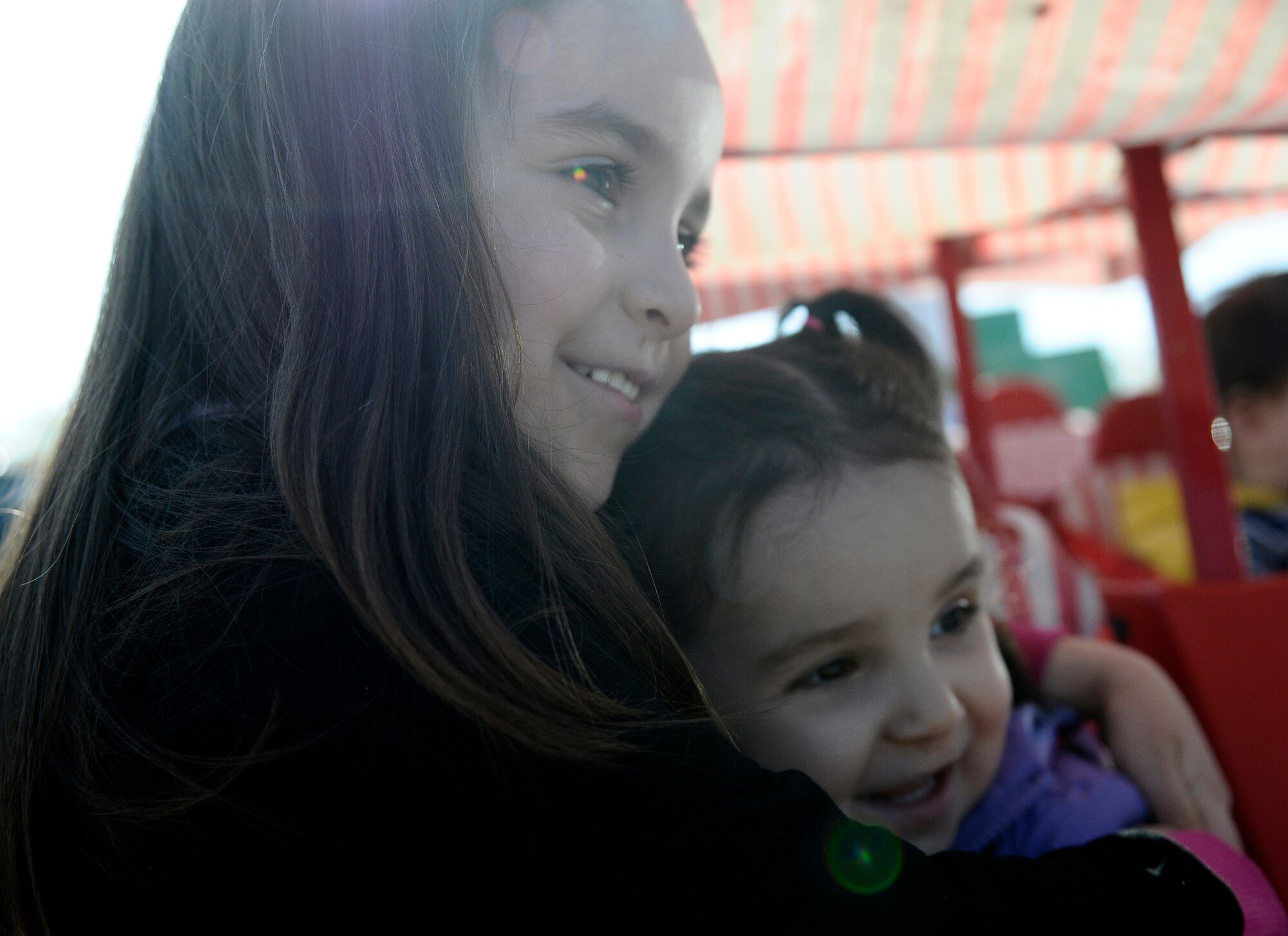 Avah and Sophia, daughters of Staff Sgt. Nadine Barclay, a photojournalist deployed from Aviano Air Base, Italy, to the 438th Air Expeditionary Wing in Kabul, Afghanistan, and Staff Sgt. Michael Barclay, a crew chief with the 31st Aircraft Maintenance Squadron at Aviano hug during a Month of the Military Child parade, April 2, 2012. Barclay is currently deployed on a six-month deployment as an advisor to Afghan air force public affairs airmen at Kabul International Airport. (U.S. Air Force photo by Senior Airman Katherine Windish)