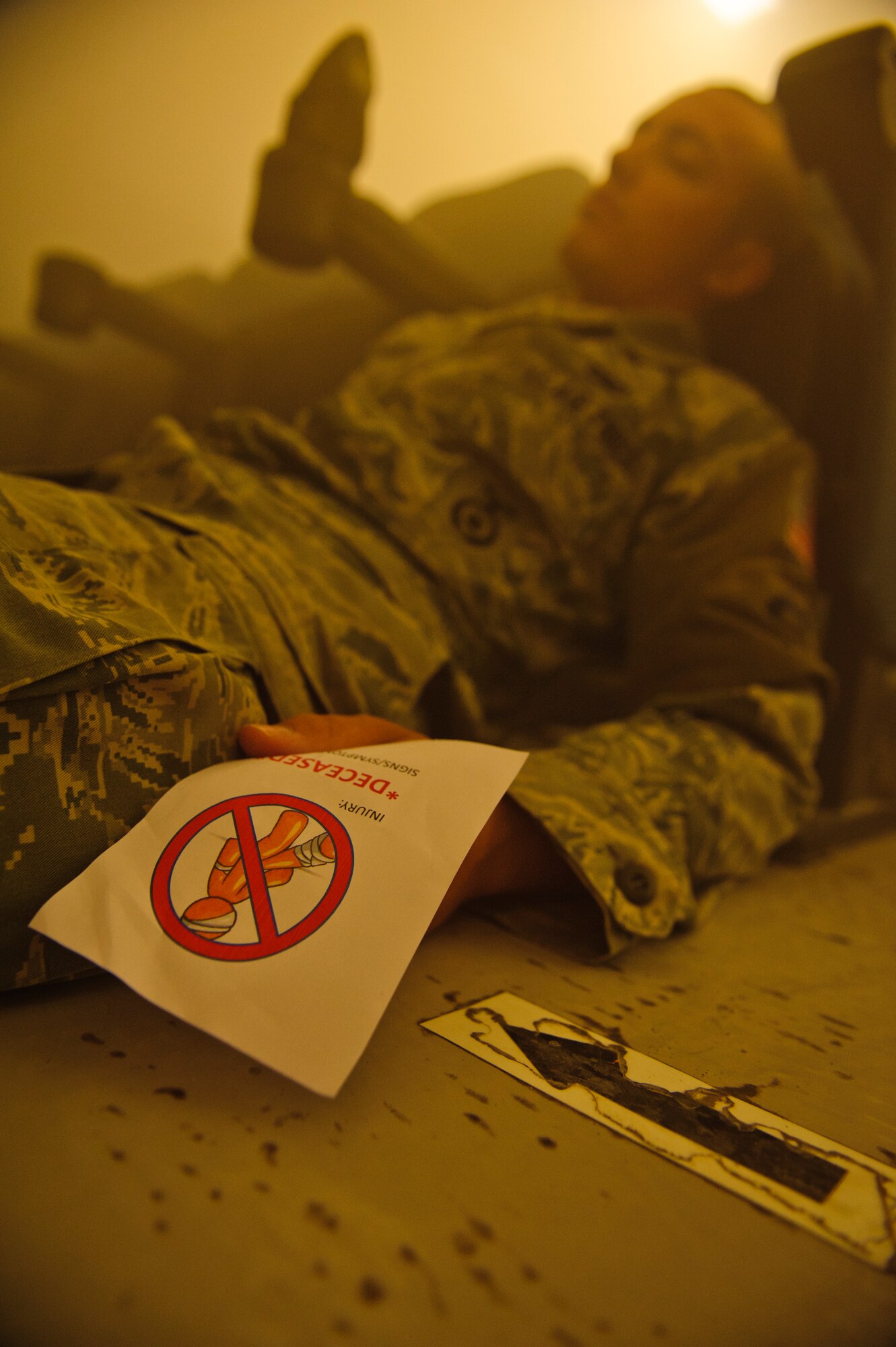 SOUTHWEST ASIA – Airman 1st Class Justin Garrett, 379th Expeditionary Security Forces Squadron simulated blast victim, lays on the ground as first responders search for survivors during a mass casualty exercise here April 6, 2012. The base participated in an exercise that simulated an explosion with numerous casualties to test first responder capabilities. (U.S. Air Force photo/Staff Sgt. Nathanael Callon)