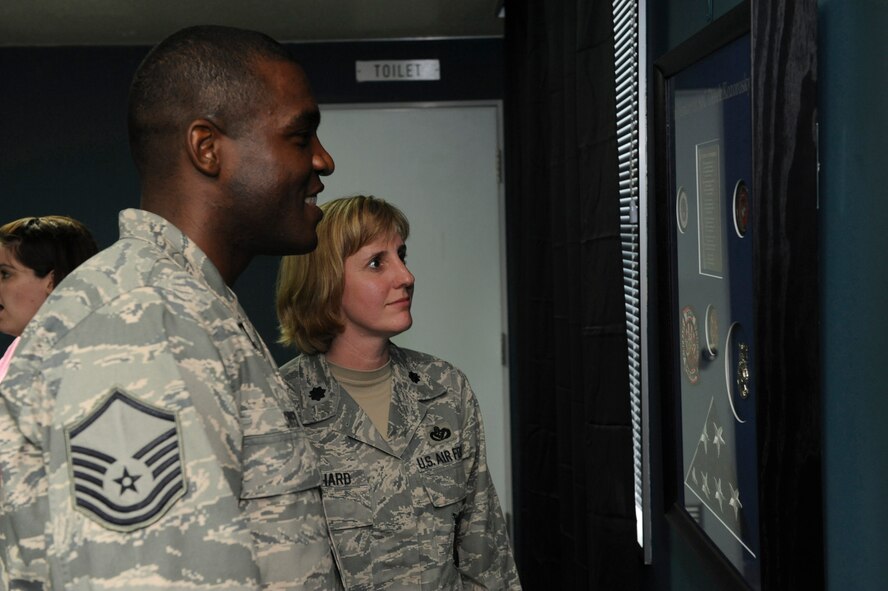 U.S. Air Force Lt. Col. Ann Birchard, 718th Civil Engineer Squadron commander, and Master Sgt. Wendell Snider, 718th Civil Engineer Squadron superintendent, admire Airman 1st Class Derek Kozorosky's accolades during the grand opening of the "Koz Mahal" on Kadena Air Base, Japan, April 11, 2012. "Koz Mahal" is a dormitory lounge dedicated in honor of Kozorosky and will be used as a recreational area for dormitory residents. (U.S. Air Force photo by Airman 1st Class Justin Veazie/released)