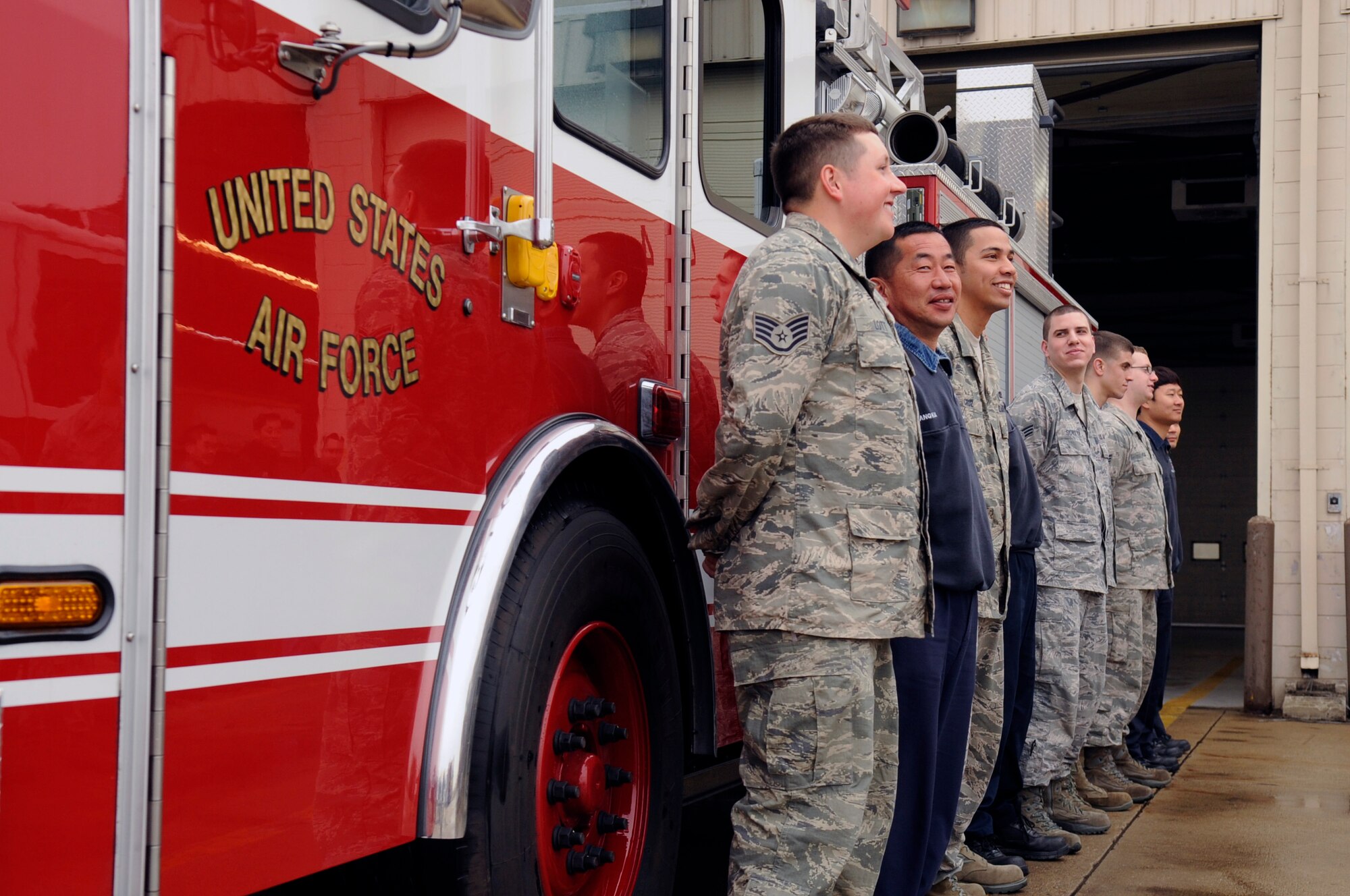 Airmen and Republic of Korea firefighters from the Kunsan Air Base Fire Department stand along one of two brand new fire trucks on Kunsan AB, Republic of Korea, April 9, 2012.  Firefighters mark the official home of new trucks by manually pushing them into the station with community members, which dates back to the 1800s. (U.S. Air Force photo/Senior Airman Jessica Hines)    