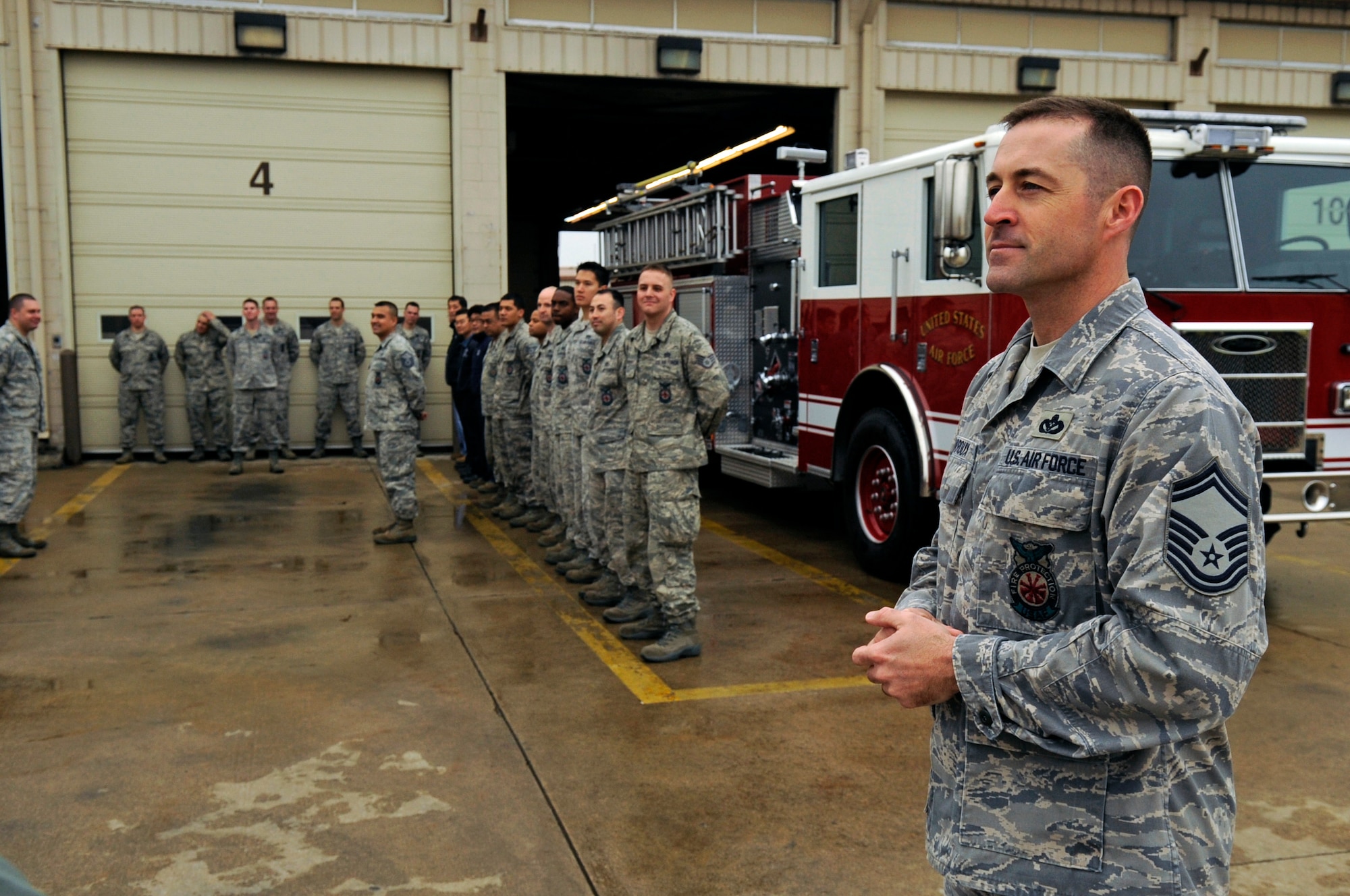 Senior Master Sgt. Philip Fourroux, 8th Civil Engineer Squadron fire chief, stands by as his station gathers together to mark the receipt of two new fire engines, April 9, 2012. In his 19 years in the Air Force, this is the fire chief’s second time taking part in the long-standing tradition to push new fire trucks into the station for the first time. (U.S. Air Force photo/Senior Airman Jessica Hines) 