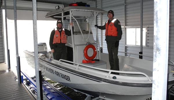COCHITI LAKE, N.M. - Park Rangers Chris Schooley (left) and Nicholas Parks situate the Cochiti Lake Project’s boat in the dock.