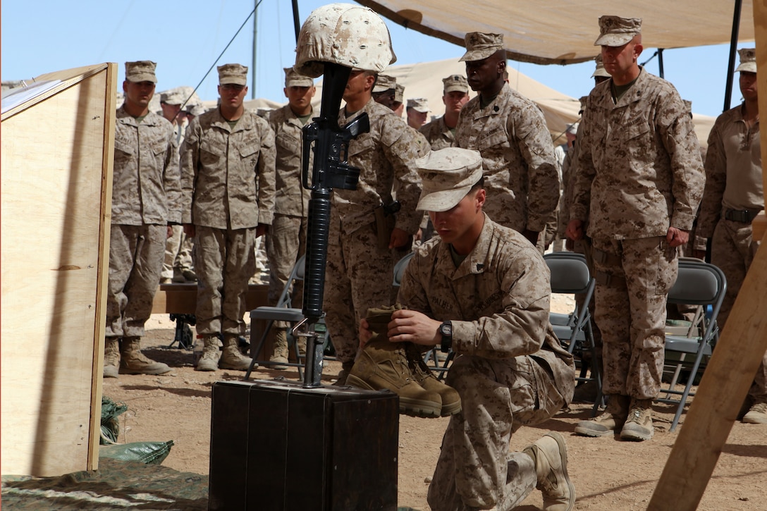 A Marine places boots in front of a memorial to signify Cpl. Alex Martinez’s last march during a memorial ceremony, April 13, 2012. Martinez was a combat engineer with 1st Combat Engineer Battalion, 1st Marine Division (Forward) and was deployed in support of 2nd Battalion, 5th Marine Regiment. He was killed in action April 5 while conducting combat operations in Now Zad District. During the ceremony, Marines spoke about the man and Marine that Martinez was and what they would remember most about him. (Official U.S. Marine Corps photo by Lance Cpl. Mark Garcia)