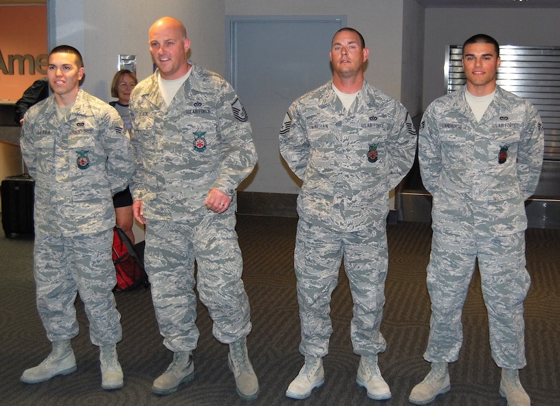 Arizona Air National Guardsmen Senior Airman Gregory Leyba, Master Sgt. Christopher Black, Master Sgt. Joe Linehan and Senior Airman Frank Landavaso are greeted April 13 in the Tucson International Airport baggage claim. The firefighters from the 162nd Fighter Wing spent the last six months deployed to Southwest Asia. (U.S. Air Force photo/Airman 1st Class Roberto Gonzalez)