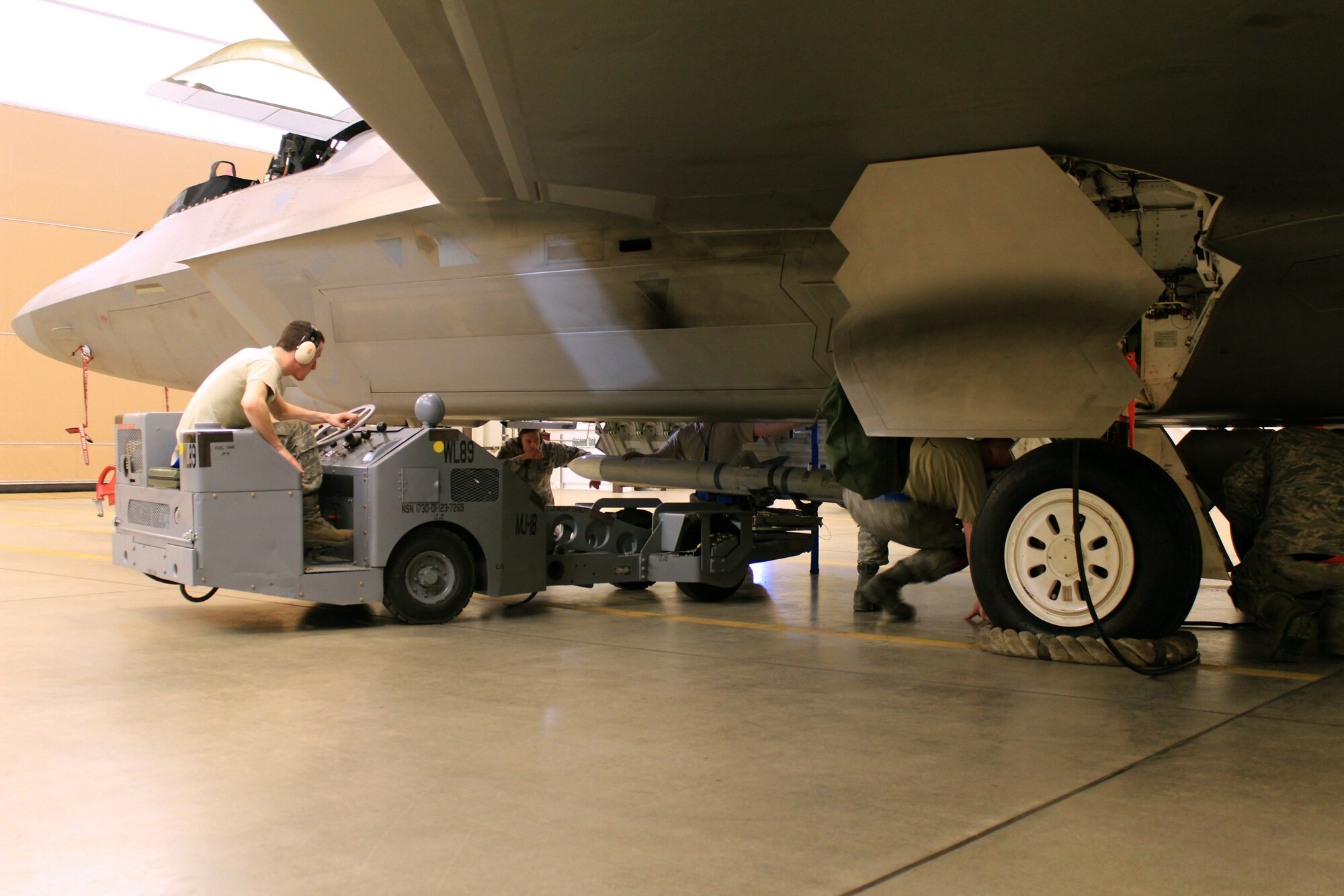 Senior Airman Joshua Baker, a Traditional Reservist with the 477th Aircraft Maintenance Squadron Weapons Flight, is operating the jammer as his crew loads an AIM 120 into the main weapons bay during the 1st Quarter Load Crew competition.  Baker along with an active duty and a Reserve maintainer make up the three-man team that took first place in the competition.  (U.S. Air Force/Tech. Sgt. Dana Rosso)