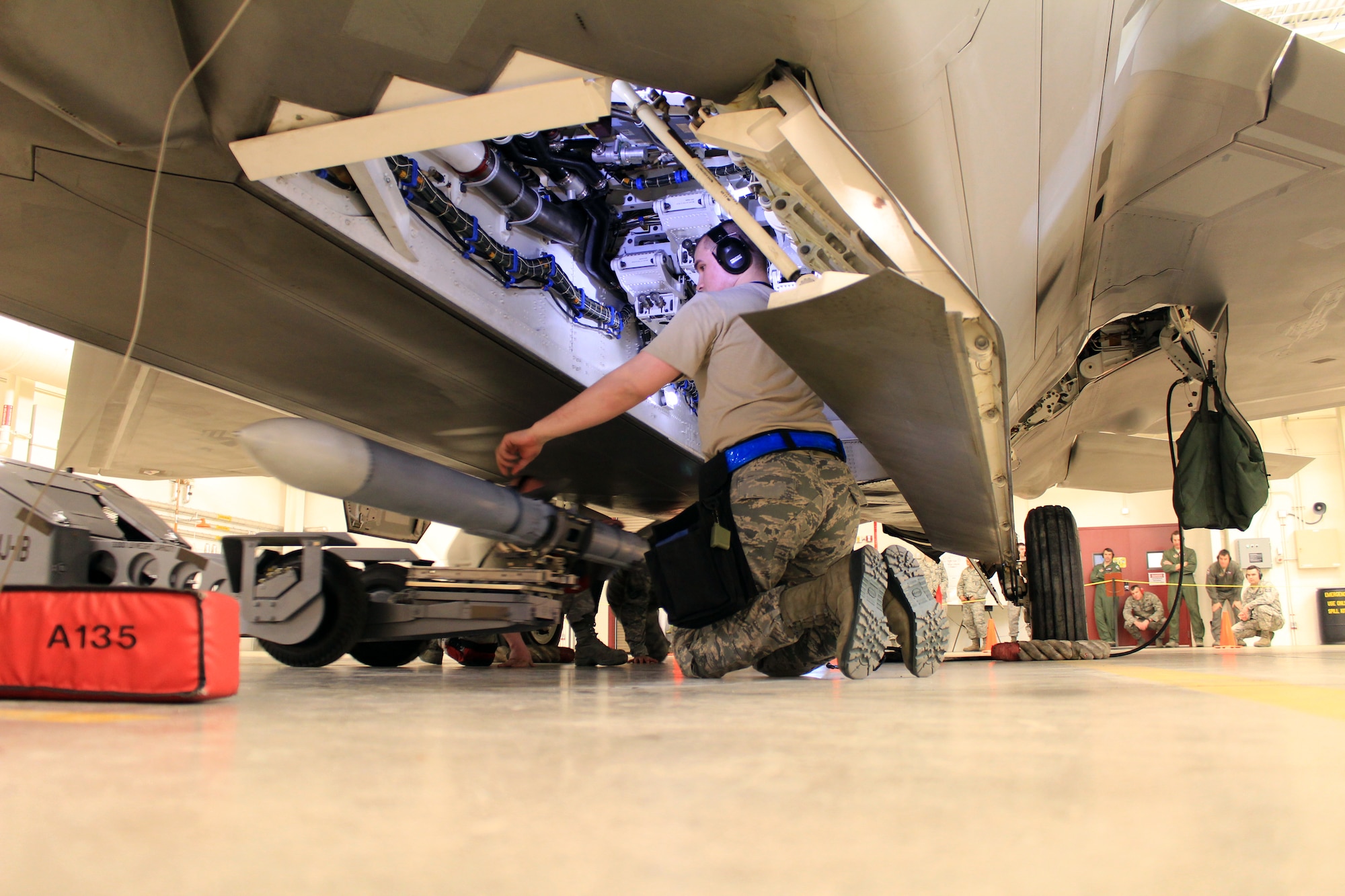 Airman 1st Class John Grimes, 3rd Aircraft Maintenance Squadron, 525th Aircraft Maintenance Unit Weapons Flight, guides an AIM 120 missile into place during the load crew competition April 12. Grimes along with two Reservists assigned to the 477th Fighter Group make up the three-man team that took first place in the competition. (U.S. Air Force/Tech. Sgt. Dana Rosso)

