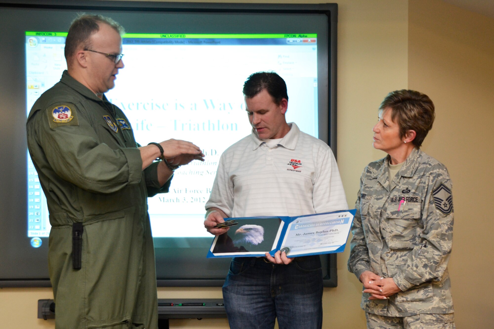 Senior Master Sgt. Joyce Hughes, Dobbins Top 3 president and Master Sgt. Richard Graddy, vice president present Jim Boylan, PhD, founder of Atlanta Triathlon Club and owner of Triathlon Coaching Services, LLC, guest speaker, with a certificate of appreciation and 700th Airlift Squadron patches at the Dobbins Top 3 meeting March 3.