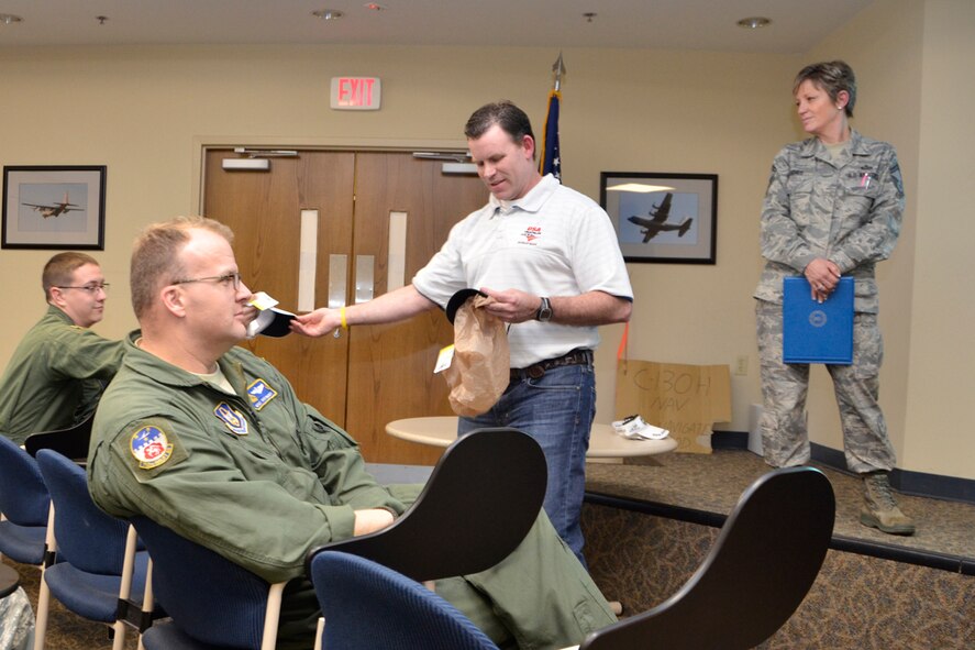 Jim Boylan, PhD, founder of Atlanta Triathlon Club and owner of Triathlon Coaching Services, LLC, hands out fitness items at the Dobbins Top 3 meeting March 3. “Socialize with people who have similar goals and priorities as you do,” said Boylan. “Get your family involved, prioritize and balance your commitments, and most off all, have fun!” (U.S. Air Force photo/Master Sgt. James Branch)