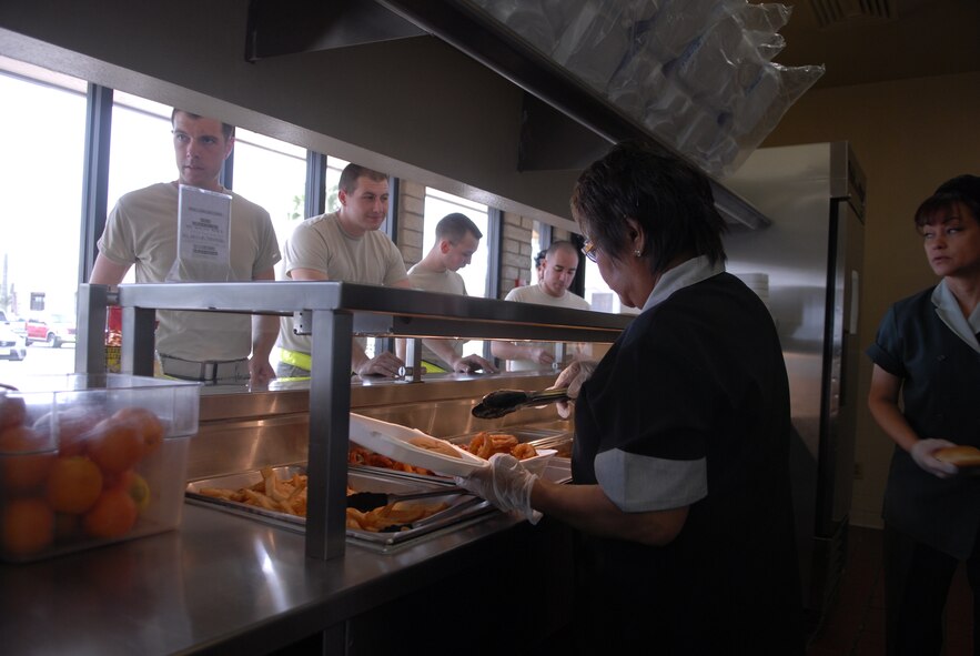 Civilian workers at the Falcon Flight Kitchen on Luke Air Force Base serve lunch to Airmen April 14.  The flight kitchen accommodates more than 150 Airmen on the west end of base who have limited time for lunch and dinner.  Any military member in uniform and authorized civilians are welcme to eat  at the flight kitchen with a meal card or cash.  (U.S. Air Force photo by Senior Airman CJ Hatch)