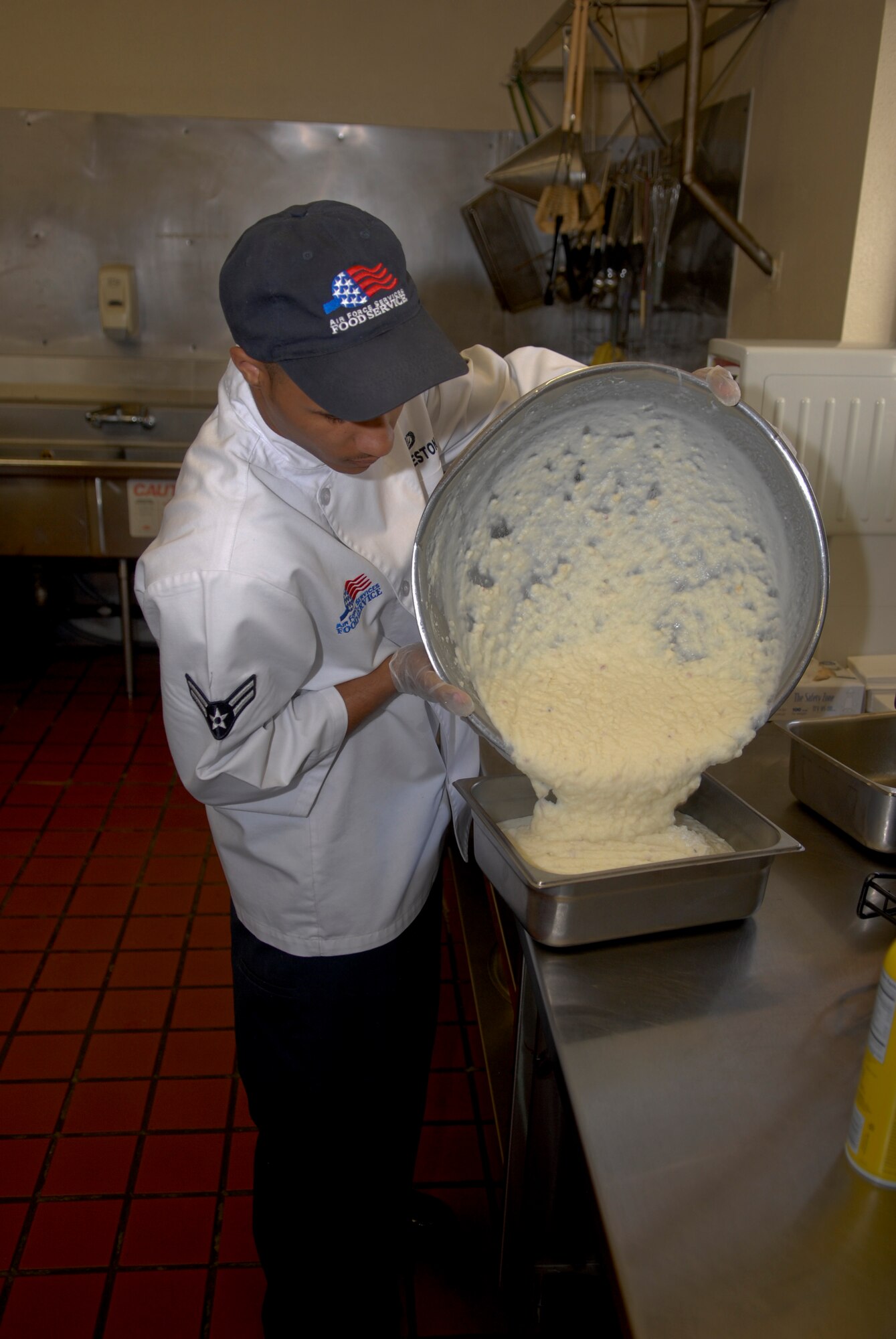 Airman 1st Class Kody Charleston, 56th Force Support Squadron Falcon Kitchen prep chef, pours mashed potatoes from a mixing bowl into a serving tray just before opening the Luke Air Force Base Falcon Flight Kitchen for lunch April 10.  The facility has a 14-day rotating menu that will always include a hot entree, a starch and a vegetable.  (U.S. Air Force photo by Senior Airman CJ Hatch)
