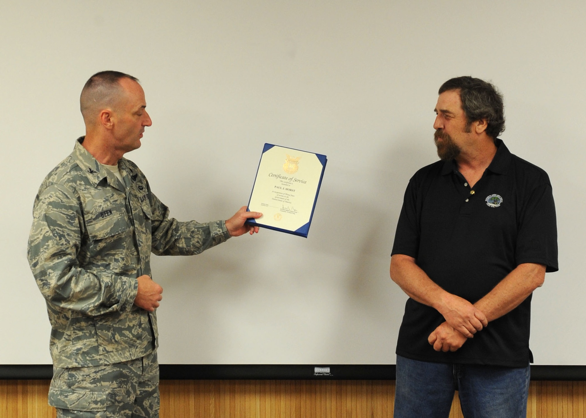 Paul Horst, 7th Force Support Squadron, is recognized for 30 years of government service by Col. David Béen, 7th Bomb Wing commander April 12, 2012, at Dyess Air Force Base, Texas. Horst began his military career in 1978 as security forces for the Air Force and currently works at the Dyess golf course. (U.S. Air Force photo by Airman 1st Class Peter Thompson/ Released)