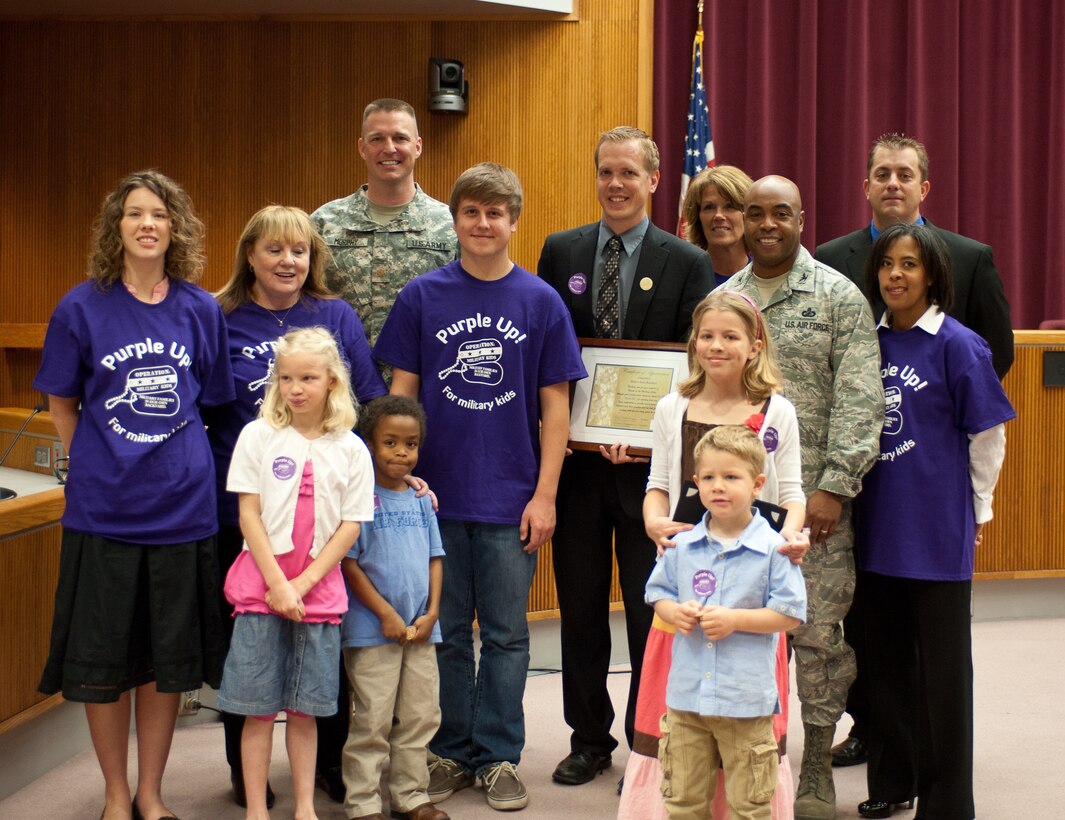 Members of Operation Military Kids and military families pose with Sam Kooiker, mayor of Rapid City, during the signing of the “Purple Up for Military Kids” Day in Rapid City proclamation event on April 12, 2012. Supporters are encouraged to wear purple to salute military kids for their courage and the sacrifices they make when their parents deploy. (U.S. Air Force photo by Airman 1st Class Alystria Maurer/Released)
