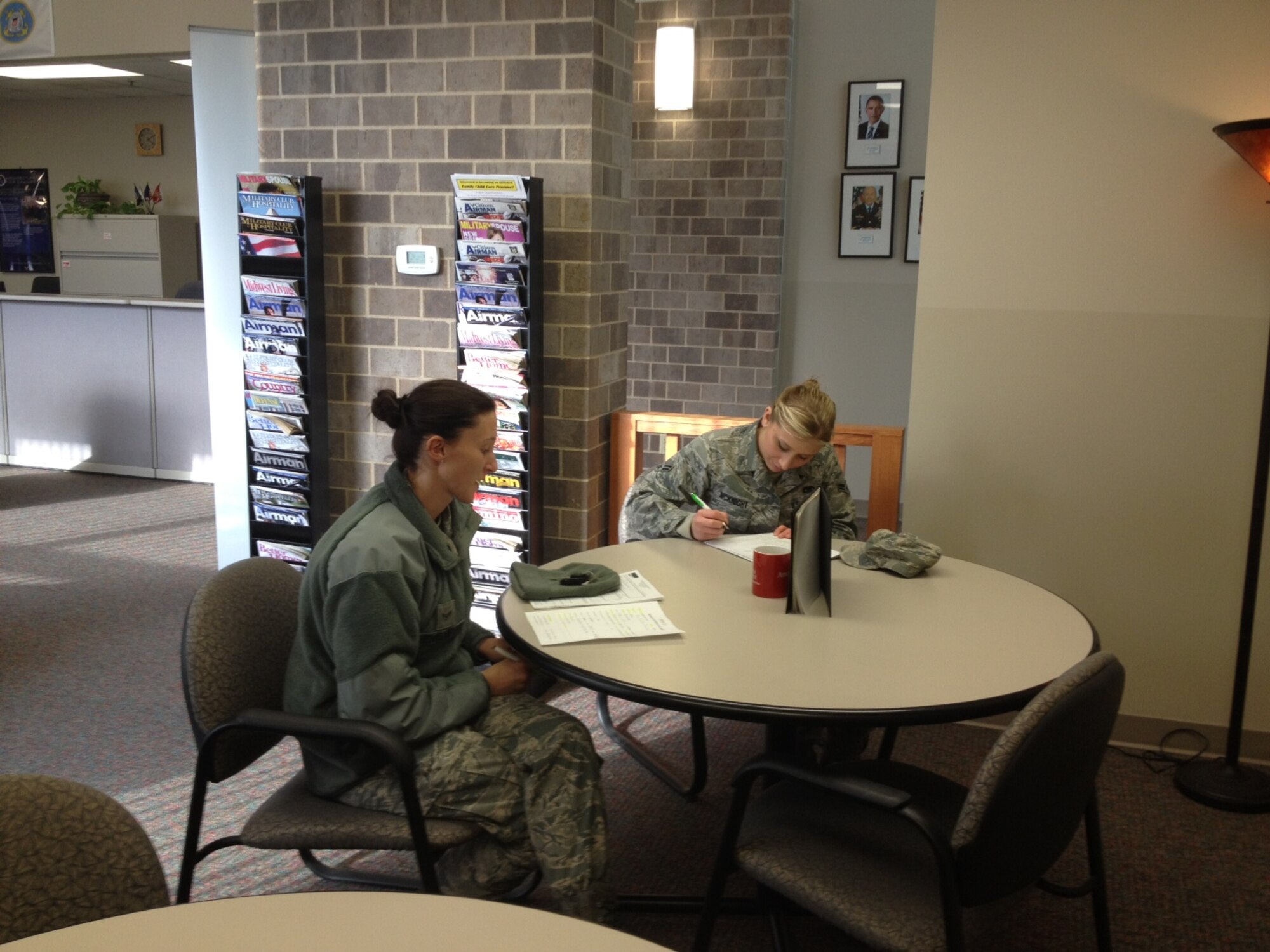 U.S. Air Force Airman 1st Class Ellen Henkemeyer (left), 55th Maintenance Group, and Airman 1st Class Bridgette McKnight (right), 55th Maintenance Operations Squadron, fill out paperwork to take advantage of an opportunity to move into Rising View Communities privatized housing while their dormitory, Whiteman Hall, goes through renovations.  Rising View Communities and 55th Wing leadership worked together to give Whiteman Hall residents an alternate place to live while renovations take place. (Courtesy Photo)