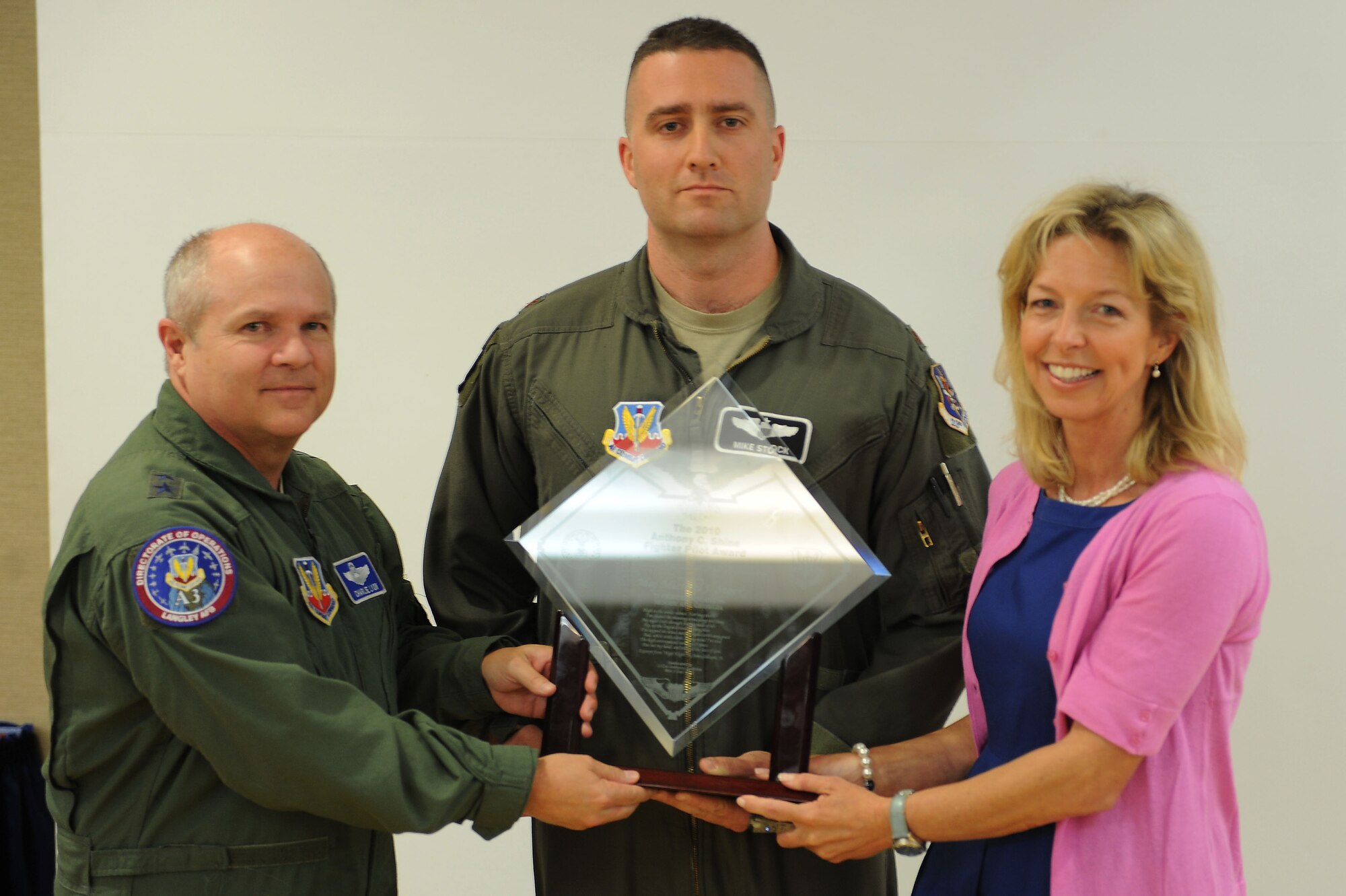 U.S. Air Force Maj. Gen Charles Lyon Headquarters Air Combat Command director of operations and Colleen Shine present the Shine Award to Maj. Michael Stock, 75th Fighter Squadron pilot, at Moody Air Force Base, Ga., April 12, 2012. The Shine Award is given annually to a pilot who is an exceptional pilot and also heavily involved with the community. (U.S. Air Force photo by Staff Sgt. Ciara Wymbs/Released)