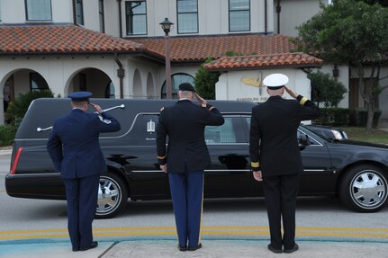 Joint Base San Antonio leaders salute the hearse transferring the body of Seaman Trevor J. Stanley, of Virginia Beach, Va., April 13 at JBSA-Randolph. Stanley was assigned to Naval Mobile Construction Battalion 3, Port Hueneme, Calif. The motorcade exited Randolph for funeral services at Colonial Funeral Home in Universal City. Stanley's family resides in the area. (U.S. Air Force photo by Joel Martinez)