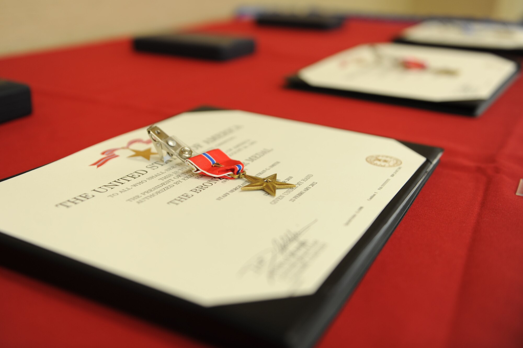 Two Bronze Star Medals and a Distinguished Flying Cross rest on display at Moody Air Force Base Ga., April 12, 2012. Staff Sgt. Jonathan Smith, 38th Rescue Squadron pararescueman, Lt. Col. James Clark, 23d Fighter Group, and Capt. Thomas Stengl, 41st Rescue Squadron scheduling officer, received the medals for actions performed while deployed to Afghanistan. (U.S. Air Force photo by Staff Sgt. Ciara Wymbs/Released) 