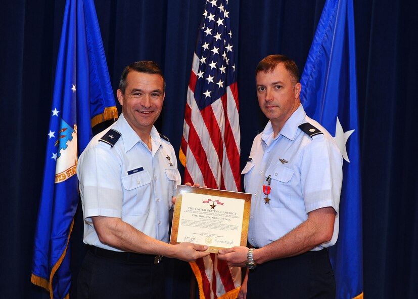 U.S. Air Force Brig. Gen. Donald Bacon, 55th Wing commander, poses with U.S. Air Force Lt. Col. Bryan Warren, 55th Wing Plans and Programs director, after presenting him with a Bronze Star at Offutt Air Force Base, Neb. April 9. Warren earned the medal during his deployment to Afghanistan as the command electronic warfare officer. His dedication to duty greatly contributed to the Combined Joint Task Force Paladin's success. (Photo by Josh Plueger/Released)