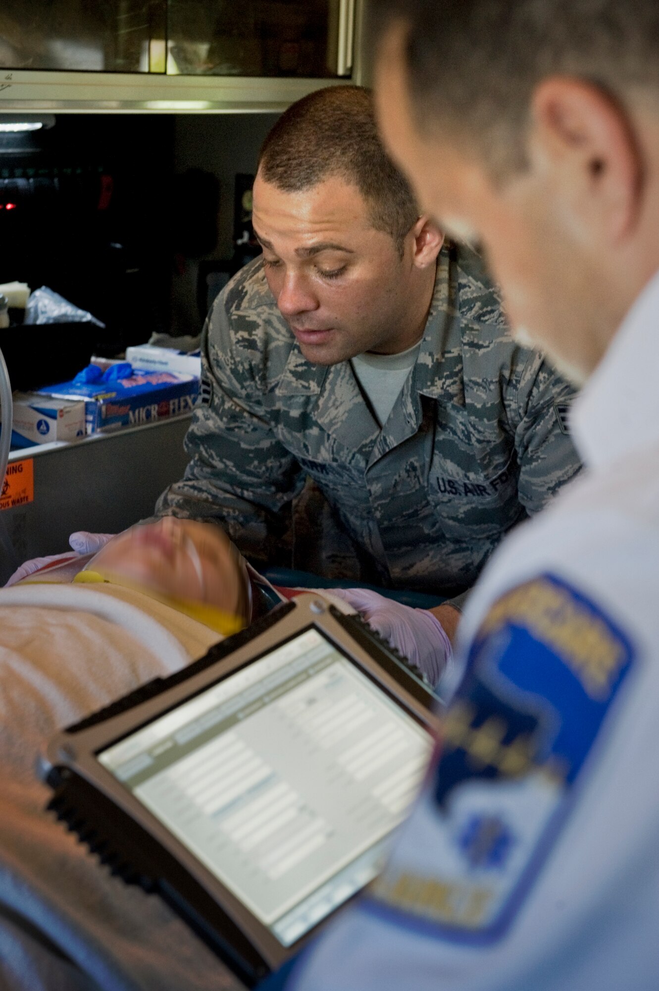 Senior Airman Jordan Clark, 7th Aerospace Medicine Squadron, left, comforts a patient while Luis Aguilar, Field Operations Paramedic, right, logs her information April 2, 2012 during training with Abilene MetroCare, in Abilene, Texas. The program allows Airmen from the 7th Medical Group to partner with MetroCare paramedics to receive additional first-responder training. (U.S. Air Force photo by Airman 1st Class Jonathan Stefanko/ Released)