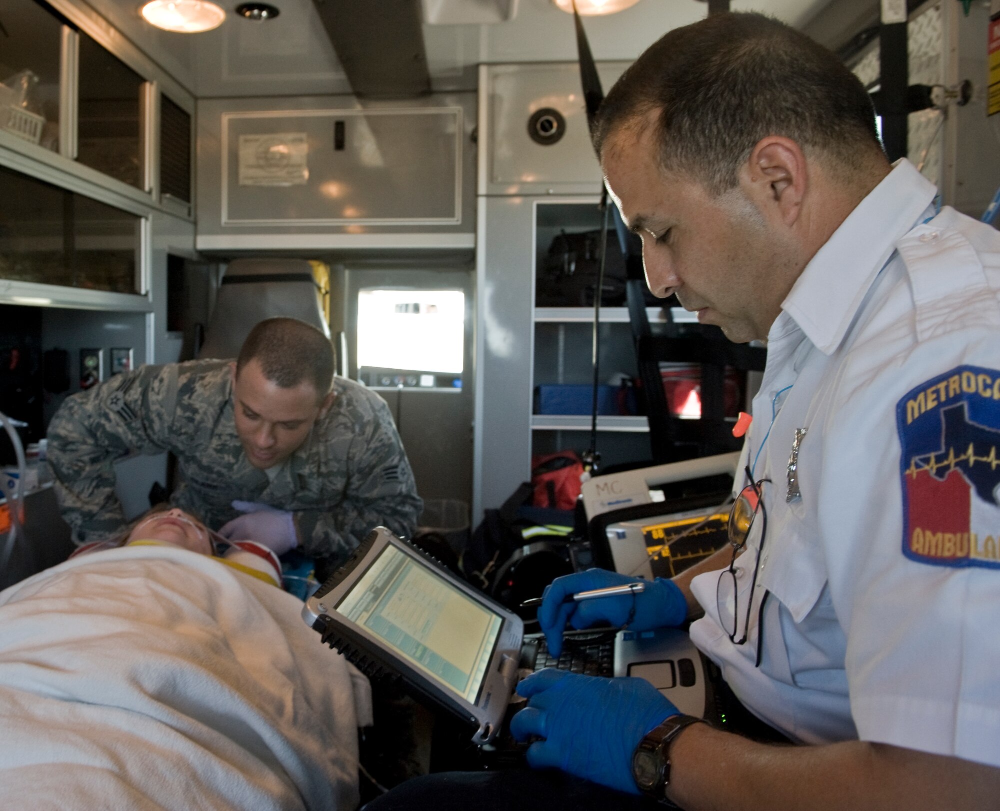 Luis Aguilar, field operations paramedic, right, logs a patient’s information while Senior Airman Jordan Clark, 7th Aerospace Medicine Squadron, left, monitors her condition April 2, 2012, during training with Abilene MetroCare, in Abilene, Texas. The program allows Airmen from the 7th Medical Group to partner with MetroCare paramedics to receive additional first-responder training. (U.S. Air Force photo by Airman 1st Class Jonathan Stefanko/ Released)