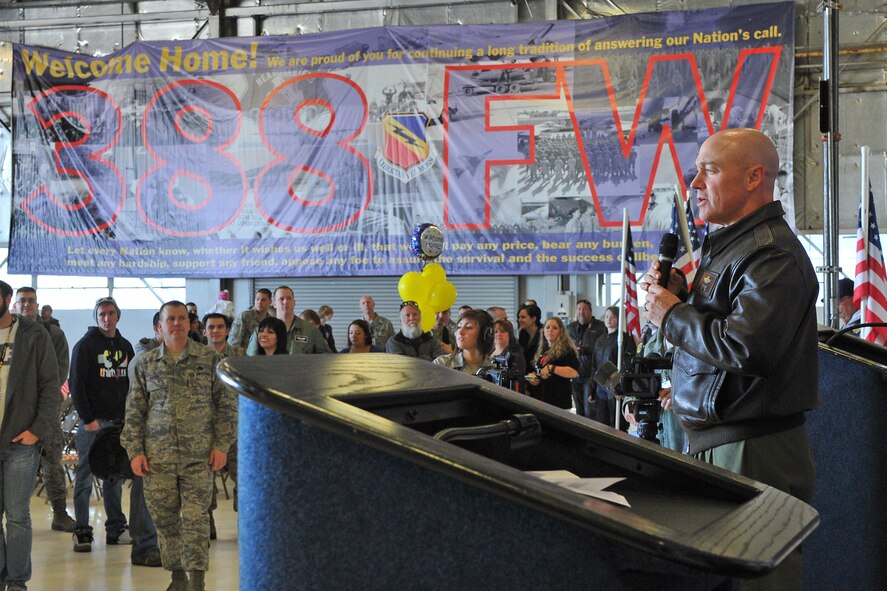 Col. Scott Long, 388th Fighter Wing commander, greets the large group of returnees April 7 with a banner to his right welcoming home the Airmen. (U.S. Air Force photo by Alex Lloyd)