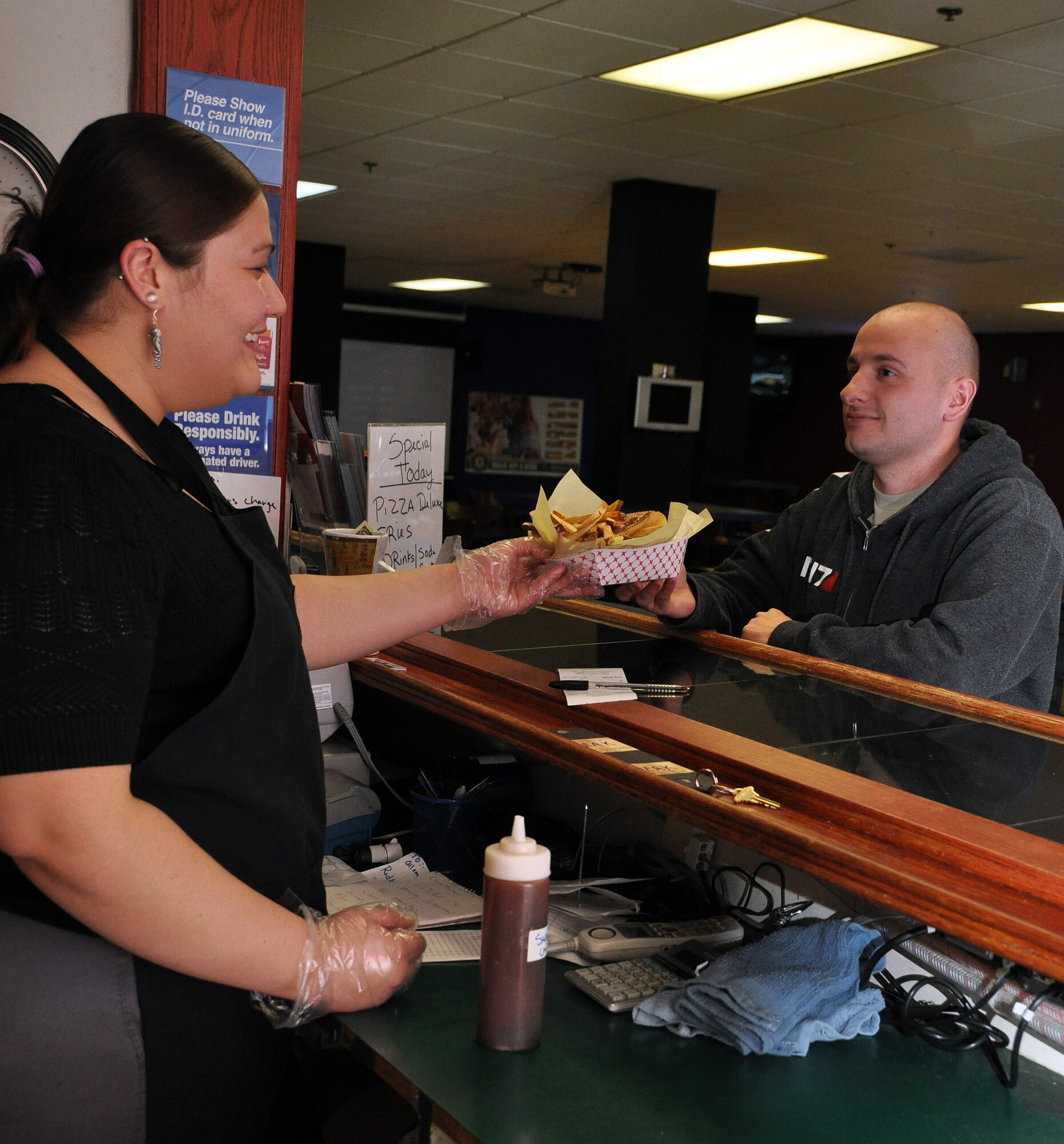Airman 1st Class Jimmy Pascal, 9th Air Refueling Squadron KC-10 Extender boom operator, receives his C-17 Globemaster III burger from the grill Tuesday inside the Airmen's Pit. (U.S. Air Force photo/Airman 1st Class Madelyn Ottem)