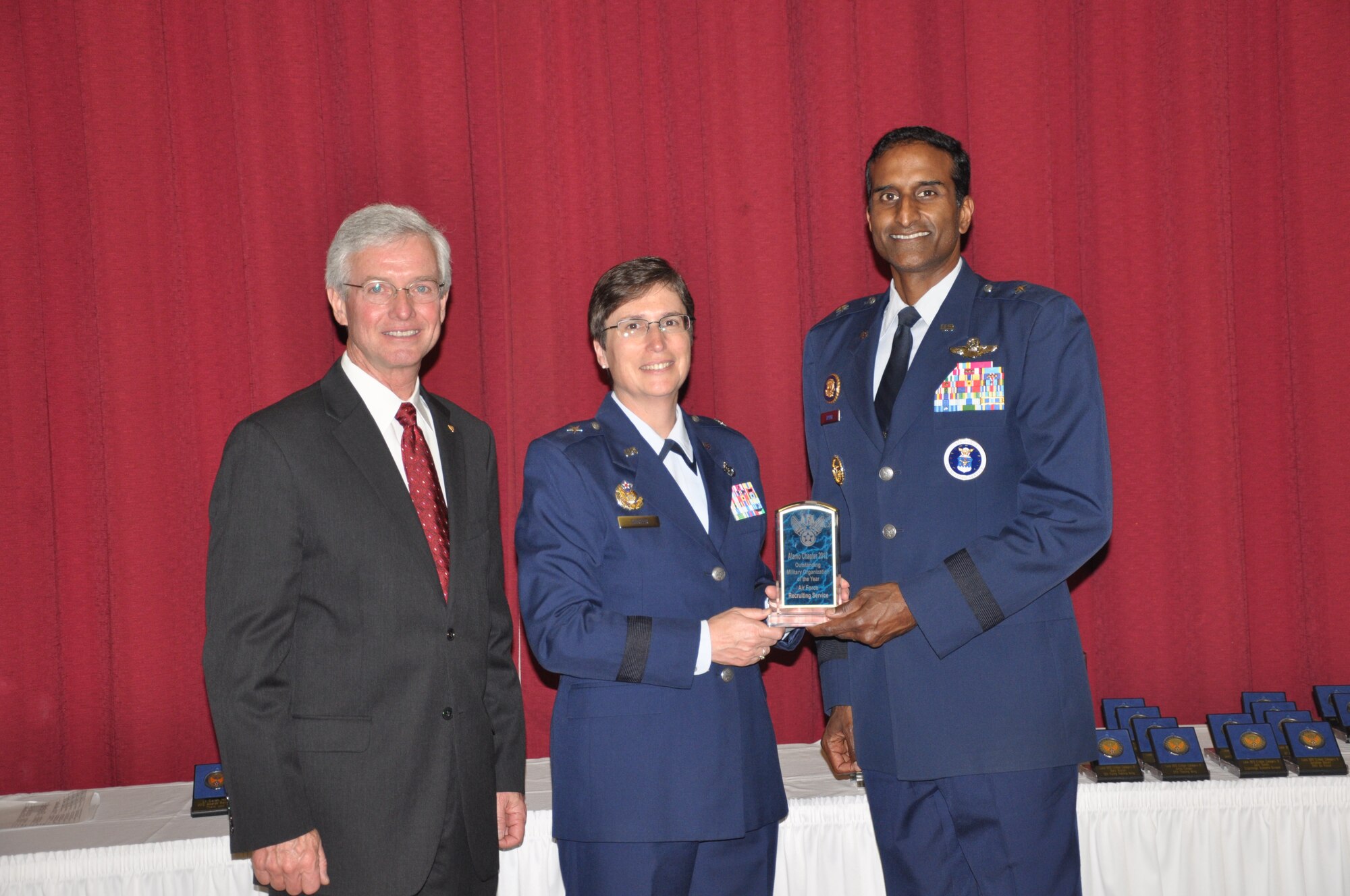 Randy Coggins (left), Air Force Association Alamo chapter president, and Brig. Gen. Theresa Carter (middle), 502nd Air Base Wing commander, present Brig. Gen. Balan Ayyar, Air Force Recruiting Service commander, with the Military Organization of the Year award at the 2012 Combined Awards Banquet at Lackland Air Force Base March 8. (U.S. Air Force photo/Capt. Maggie Silva)